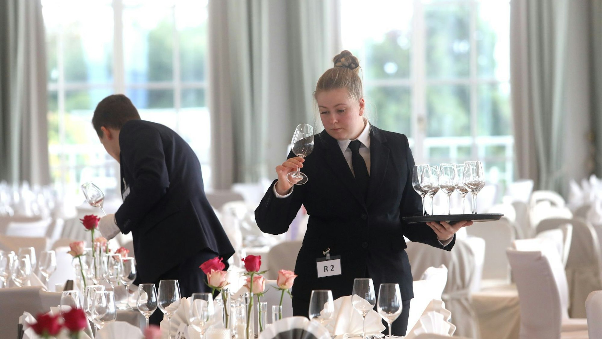 Die Wettbewerbsteilnehmer decken gerade die Wettbewerbstische.