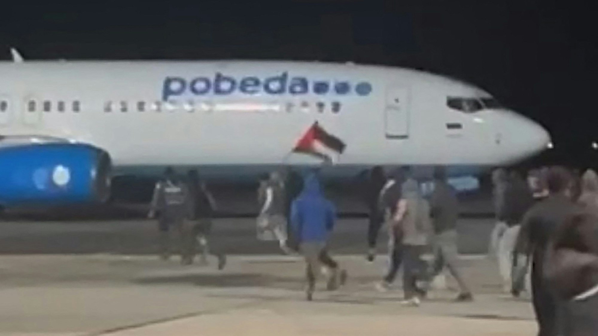 Eine Person schwenkt eine Palästina-Fahne auf dem Flughafen in Dagestan.