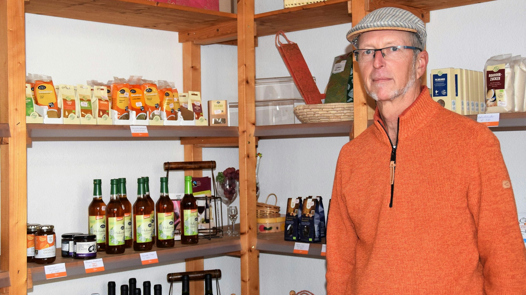 Ein Mann steht vor einem Regal mit fairen Produkten.