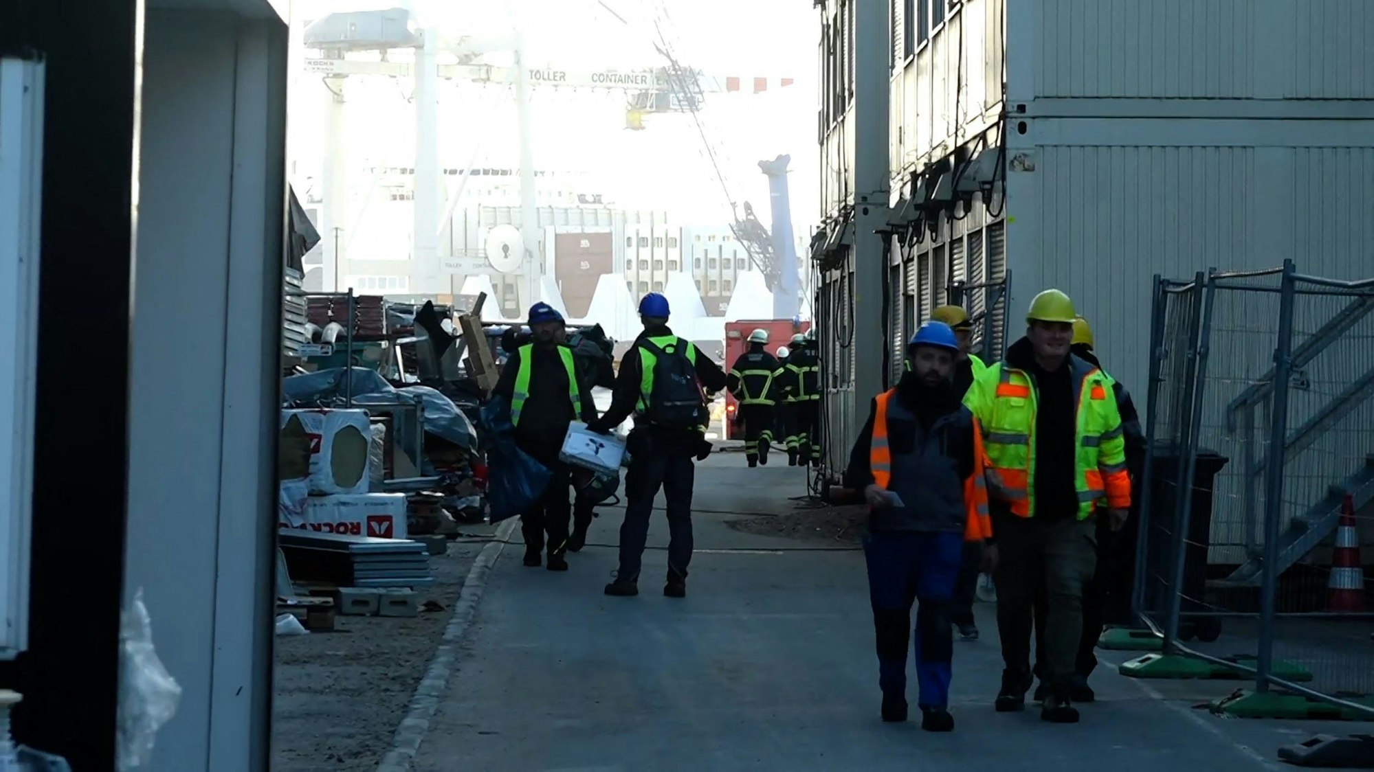 Einsatzkräte der Feuerwehr begehen den Unfallort in der Hamburger Hafencity.