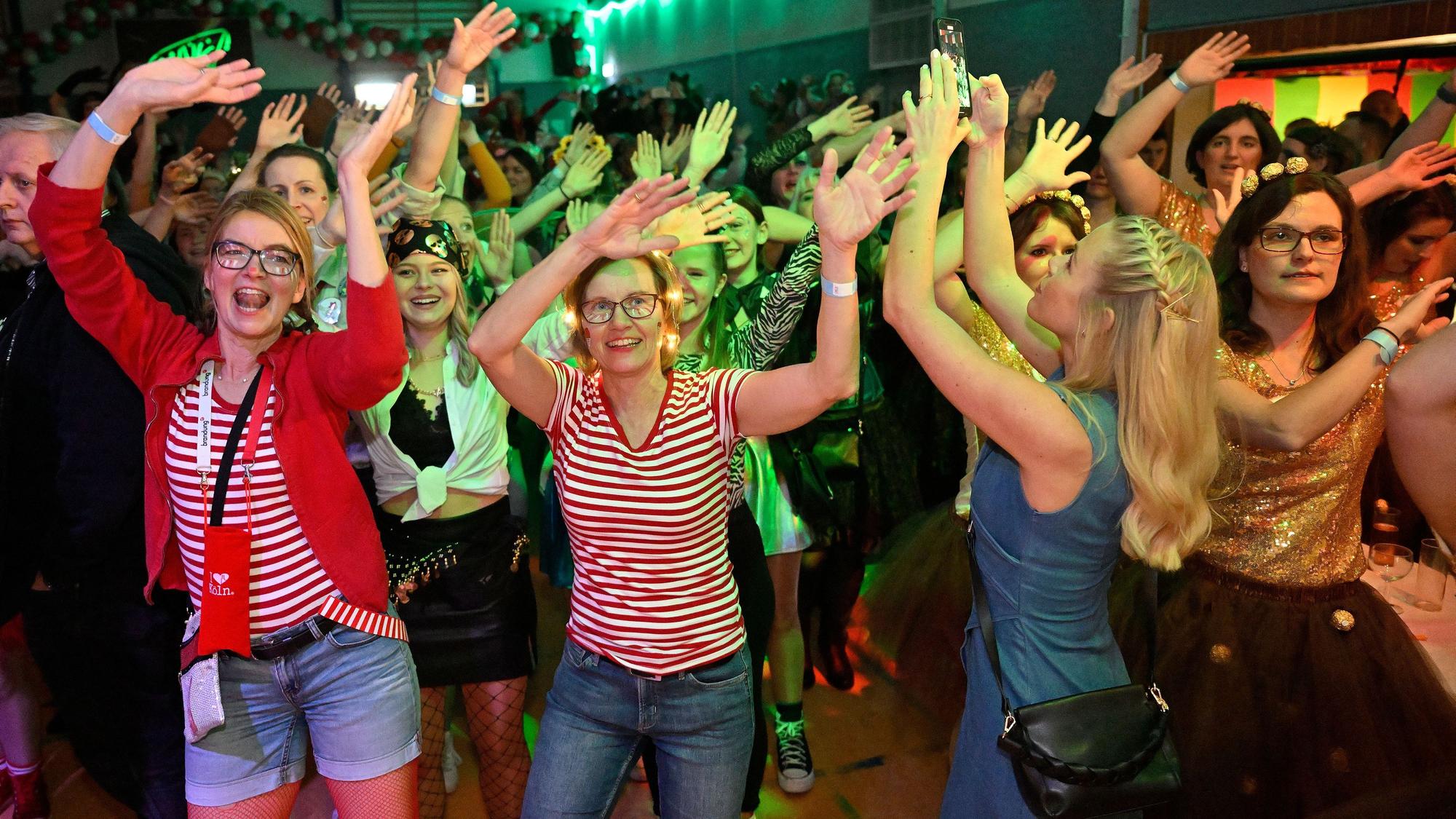 Kostümierte Frauen singen und heben die Hände in die Höhe.