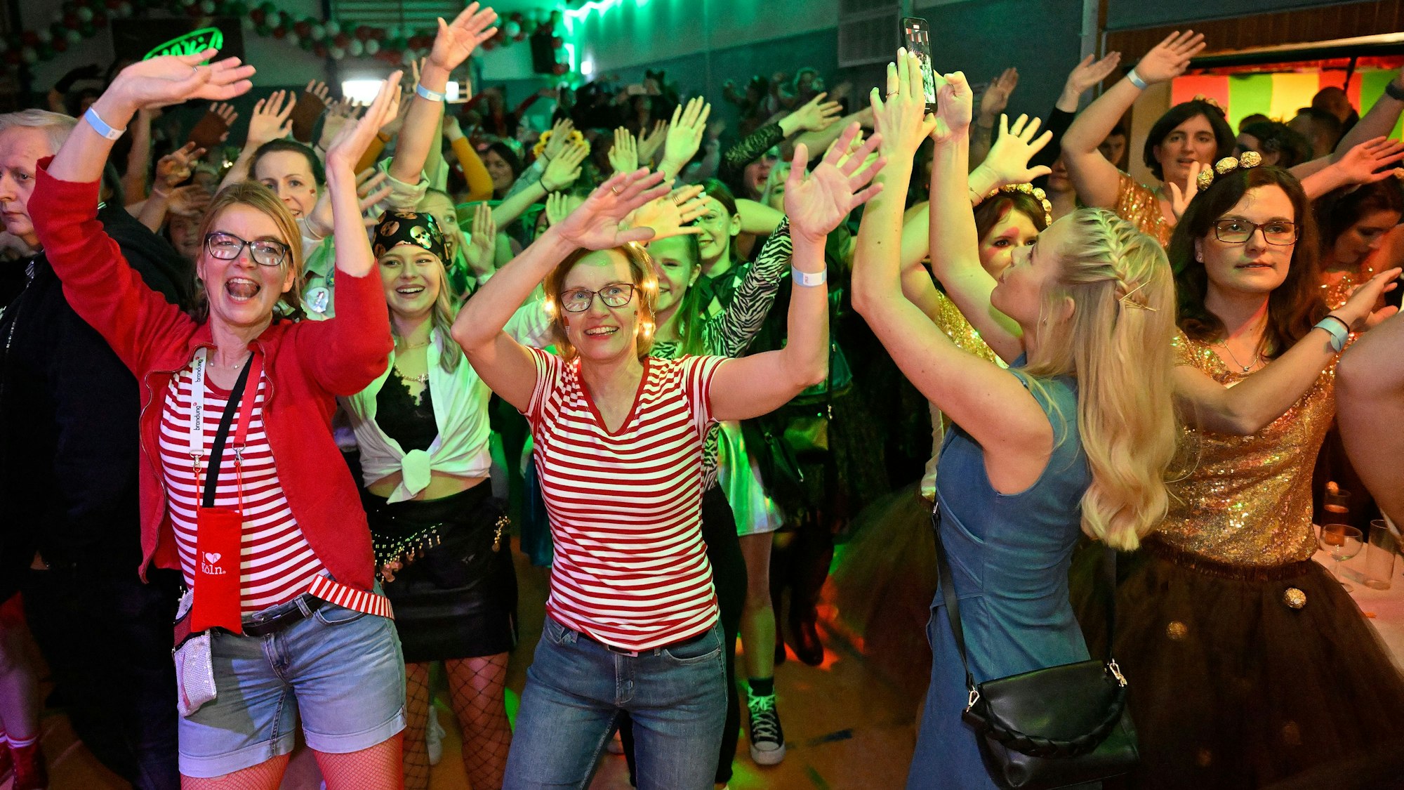 Kostümierte Frauen singen und heben die Hände in die Höhe.