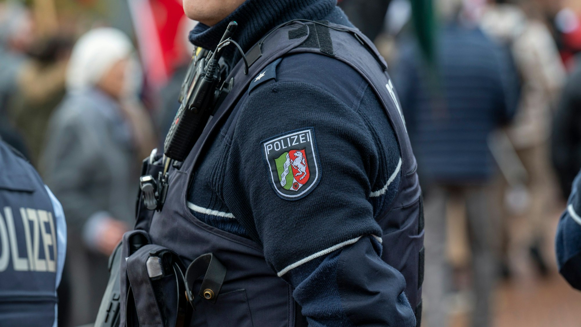 Ein Kölner Polizist steht auf einer Straße.