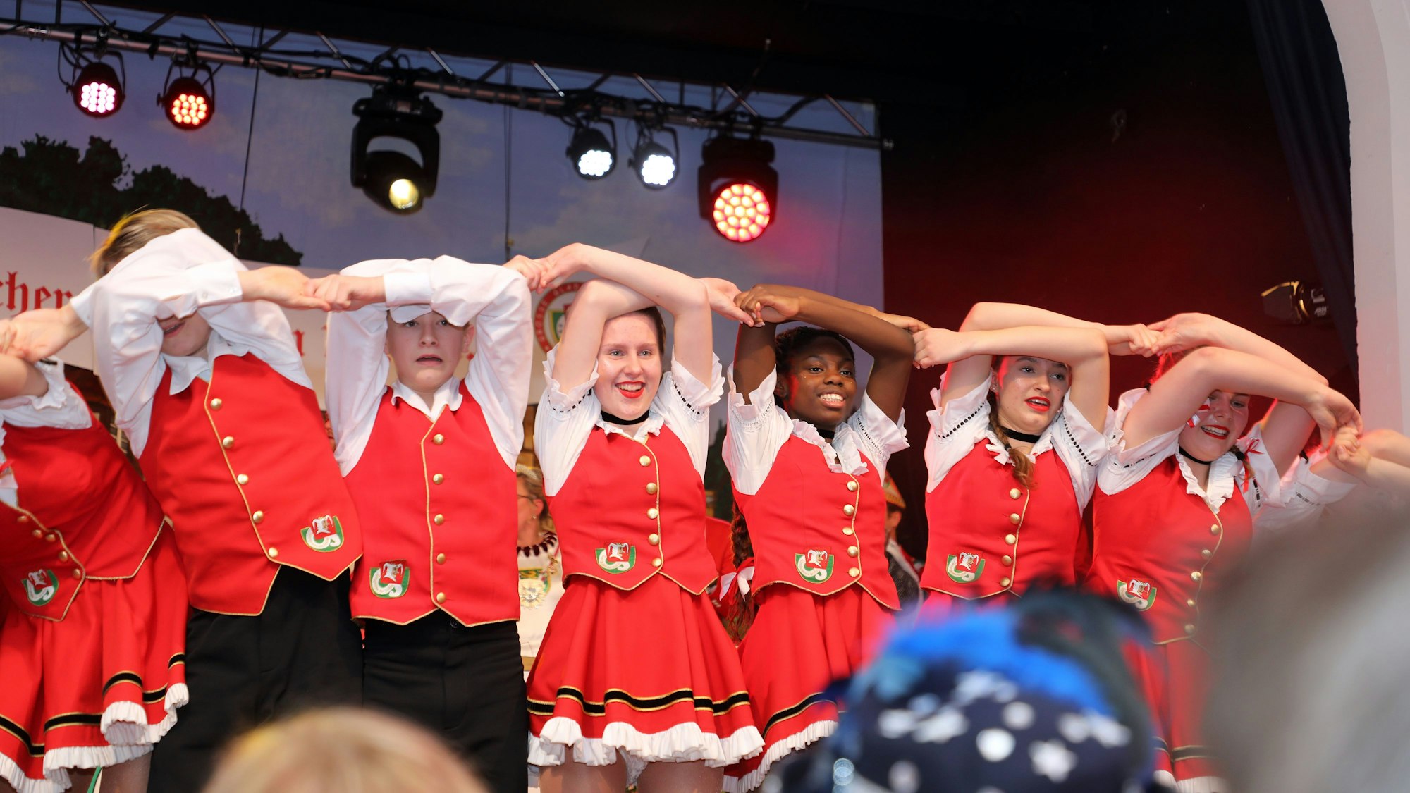 Tänzerinnen und Tänzer machen eine Welle auf der Bühne.