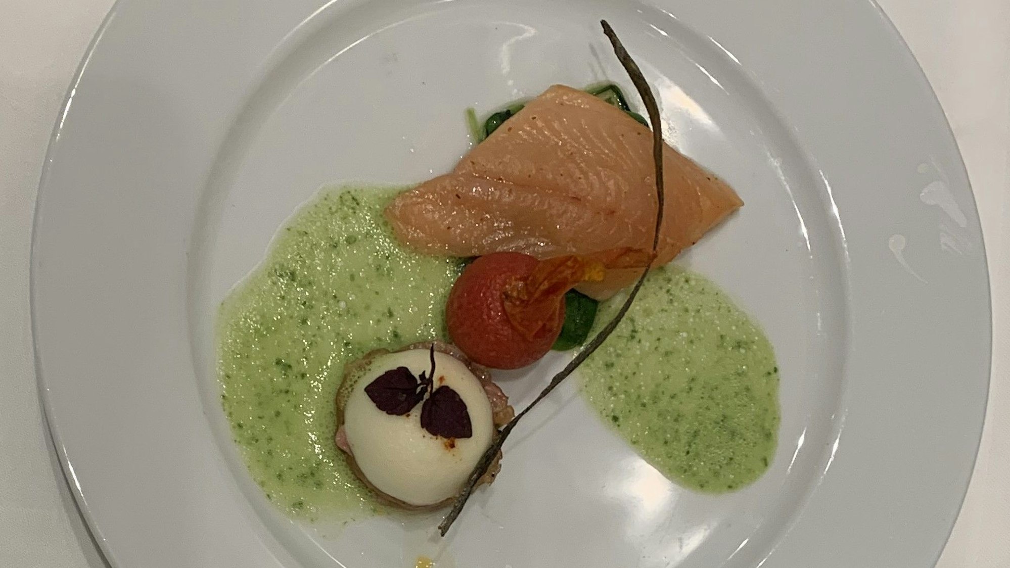 Ein Saibling liegt auf einem Speiseteller.