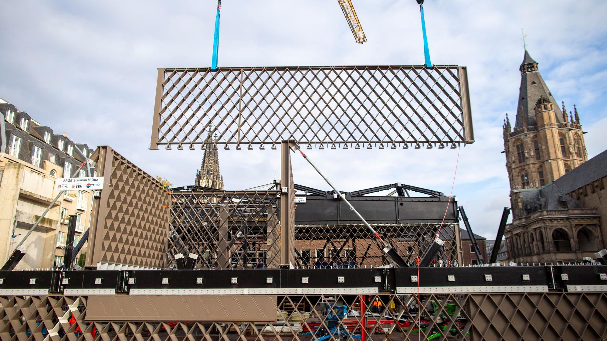 Ein Stahlbauteil mit Rautenmuster wird an der MiQua-Baustelle angeliefert.