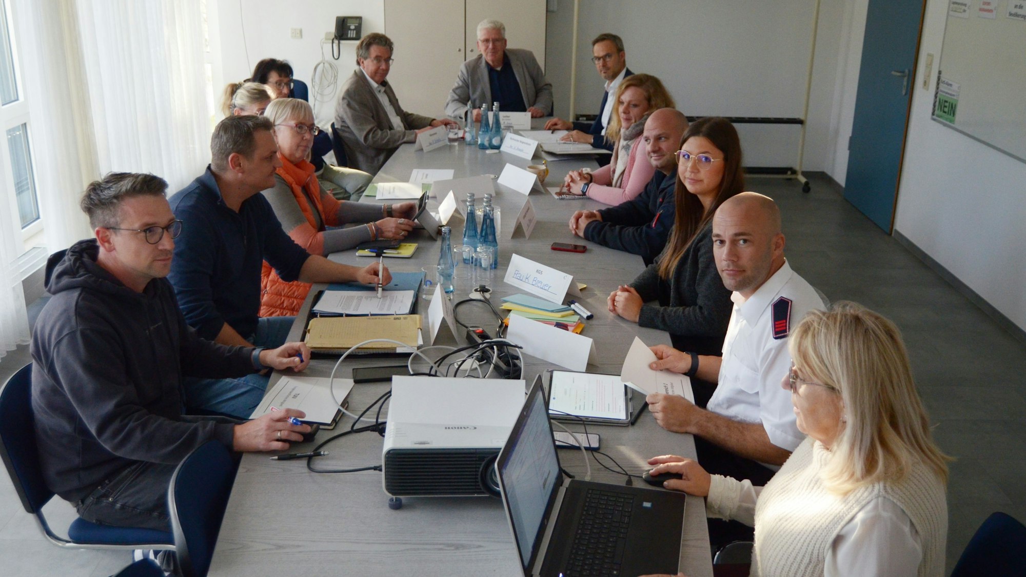 Mitarbeiter der Euskirchener Stadtverwaltung sitzen in einem Konferenzraum mit sorgenvollen Blicken an einem Tisch.