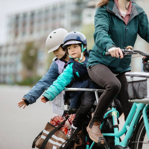 Frau fährt mit zwei Kindern auf dem Fahrrad Foto: Getty Images/RyanJLane