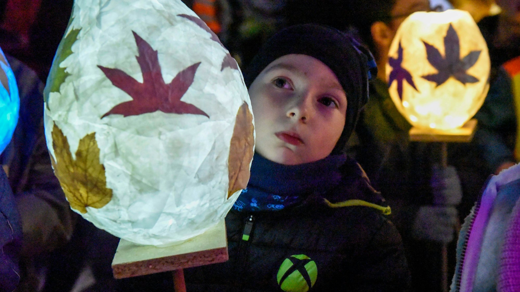 Kinder zeigen ihre selbstgebastelten Laternen.