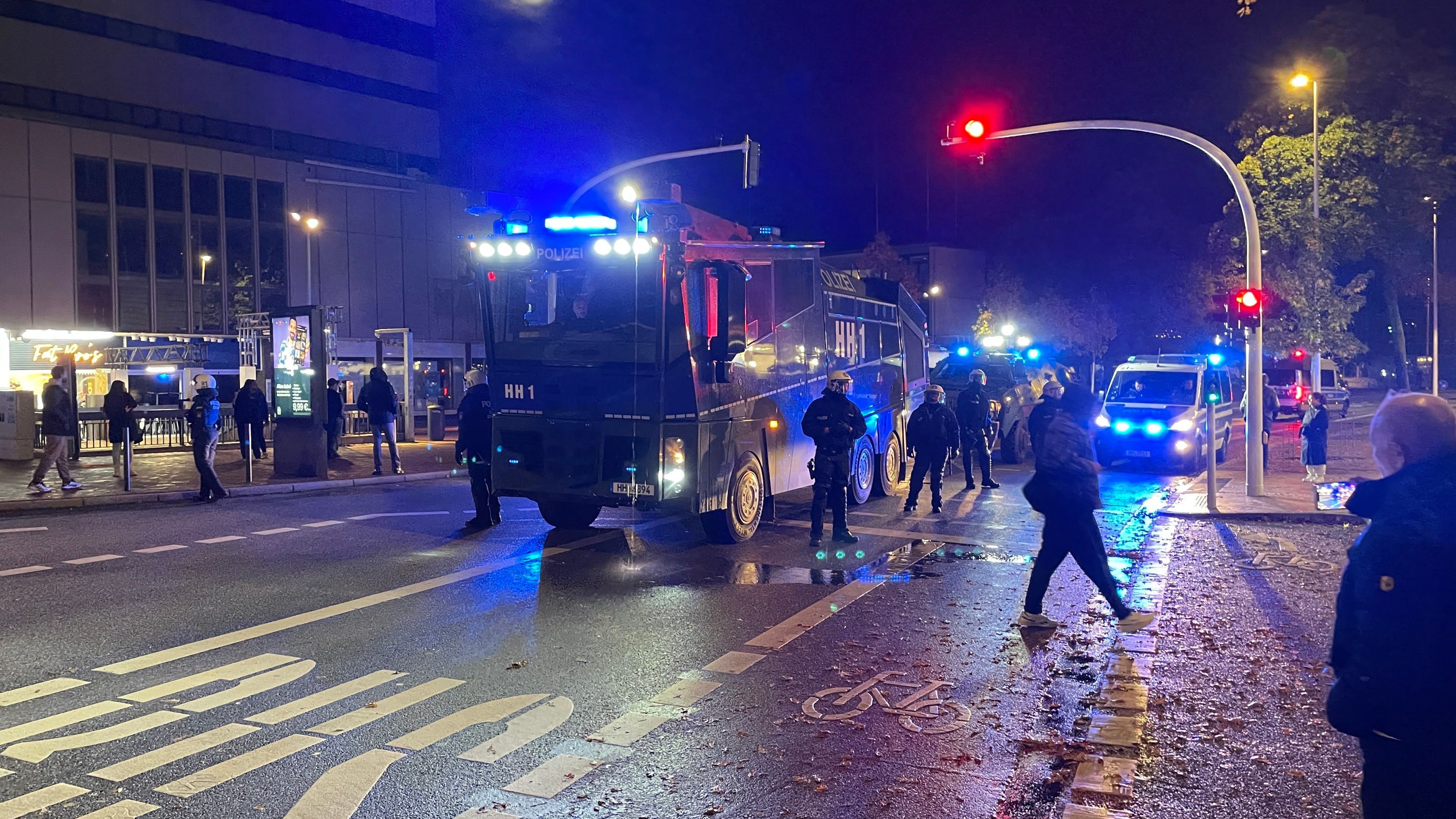 31.10.2023, Hamburg: Einsatzkräfte der Polizei stehen neben Einsatzfahrzeugen in Harburg.