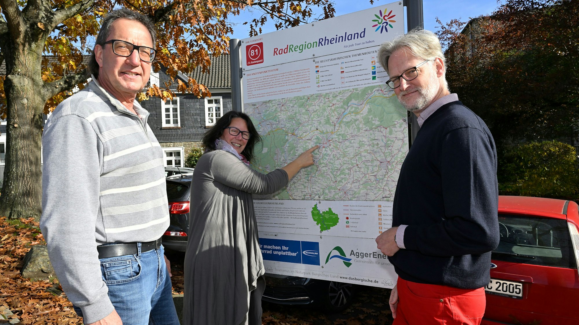 Drei Menschen stehen vor einer Radwegekarte.