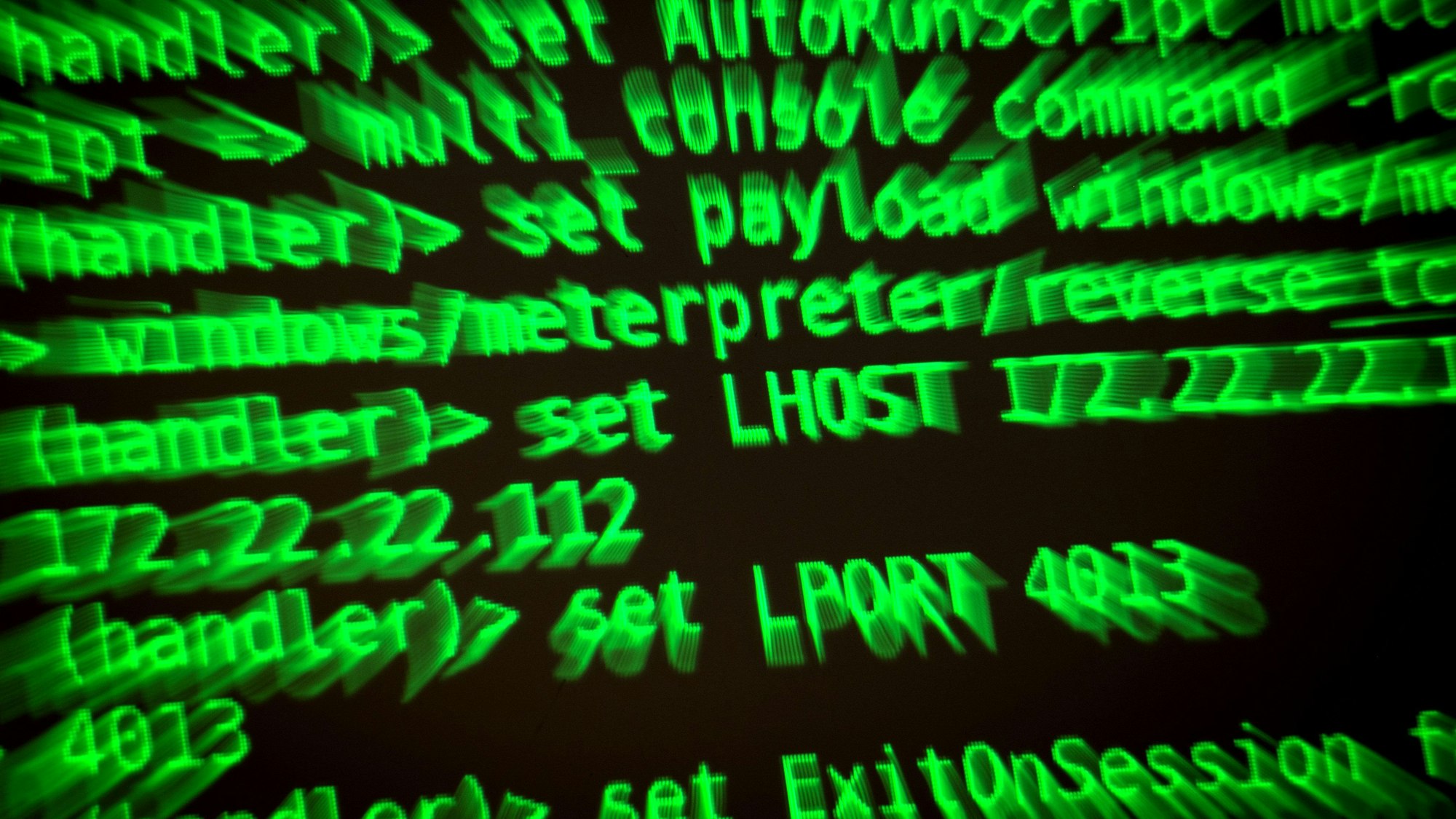 Buchstaben und Zahlen leuchten auf einem Bildschirm, auf dem ein Hacker-Programm geöffnet ist.