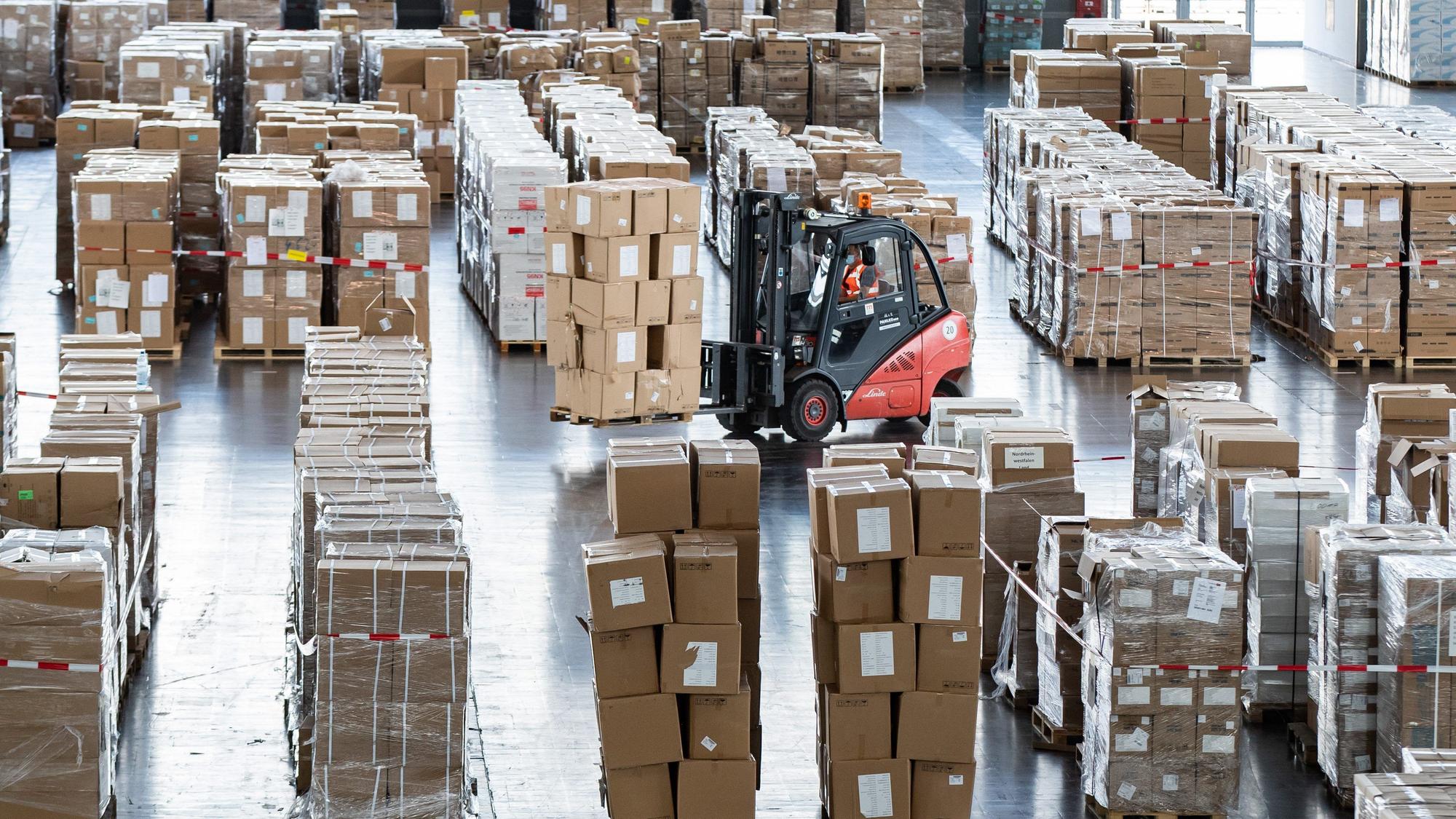 Ein Gabelstapler mit zahlreichen Kartons mit Schutzausrüstung fährt durch ein Lager. Das Land NRW muss Schutzmaterial aus der Pandemie im Wert von 33,3 Millionen Euro verbrennen lassen.