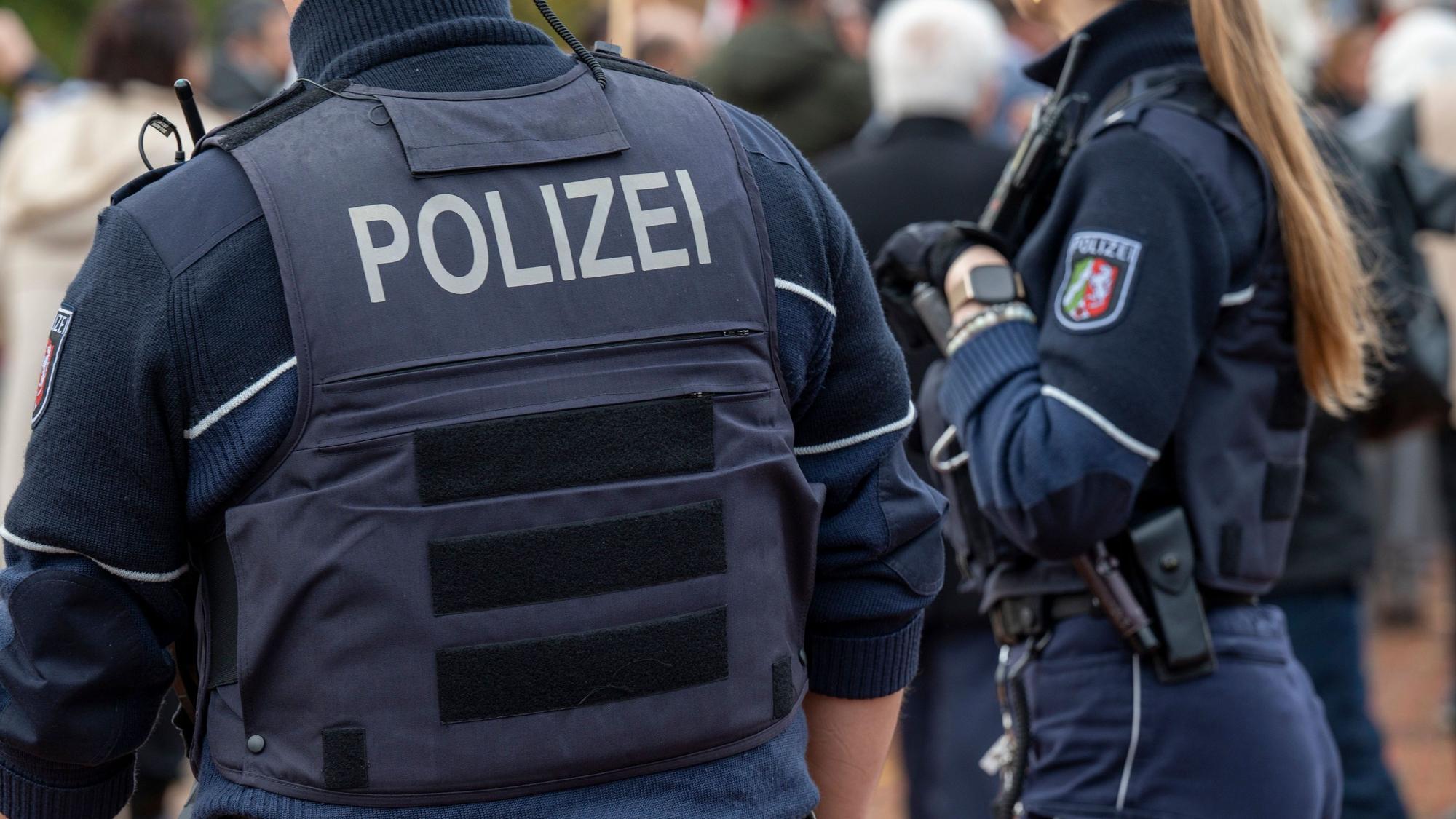 Zwei Polizisten stehen auf einem Weg.