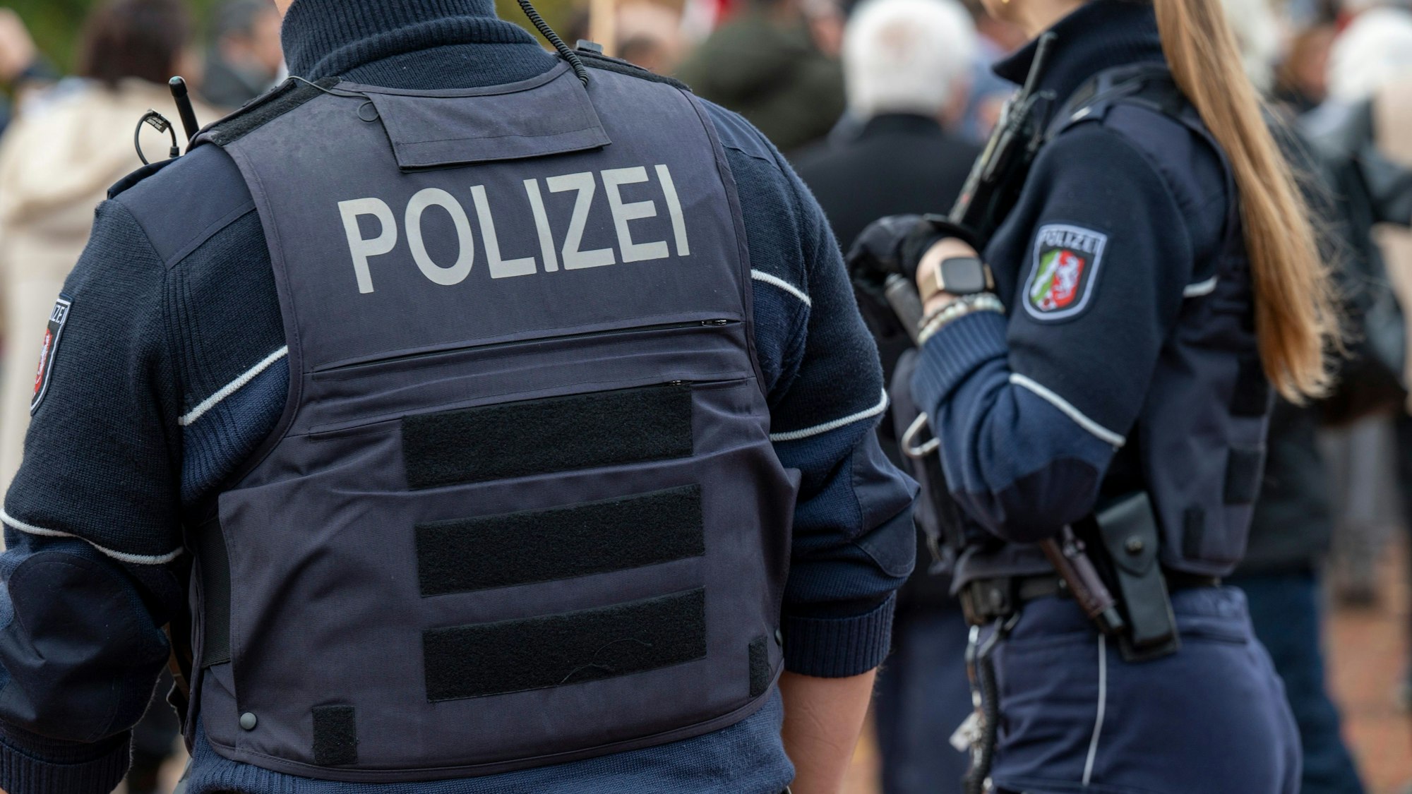 Zwei Polizisten stehen auf einem Weg.