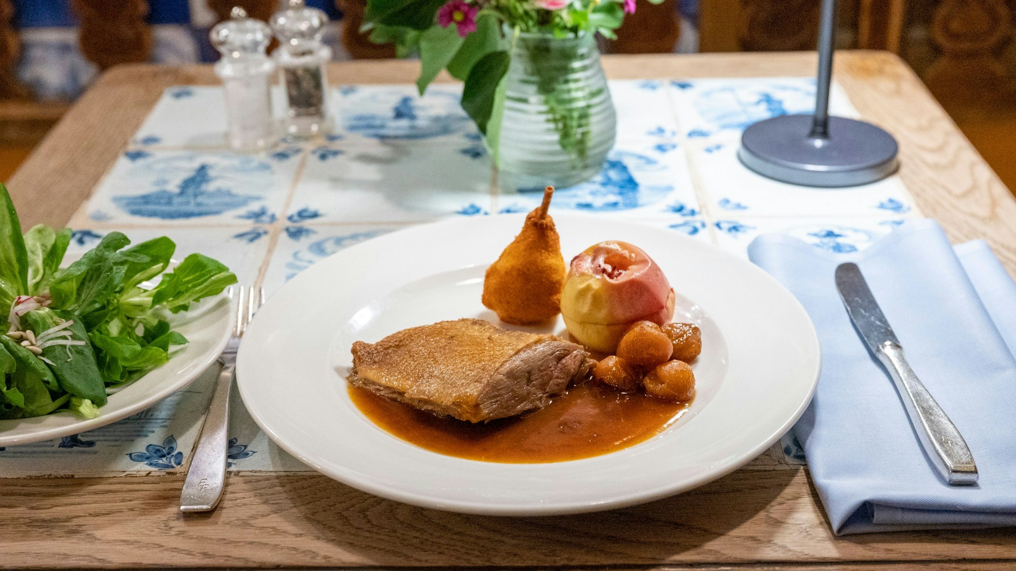 Knusprige Gänsebrust mit Bratapfel, Maronen und eine Birnenkartoffel.