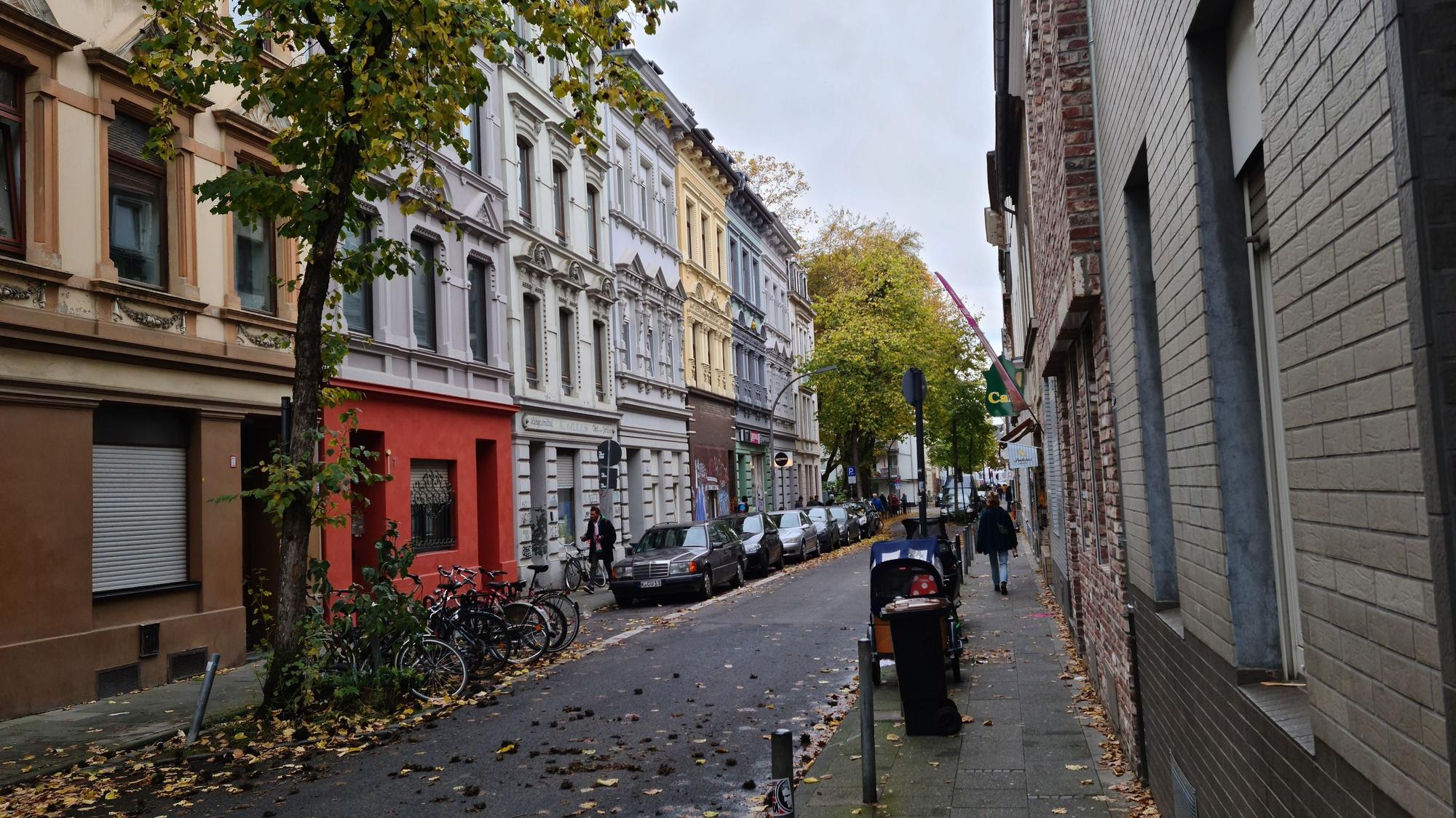 Eine schmale Straße mit teils schmucken Altbau-Fassaden ist zu sehen.