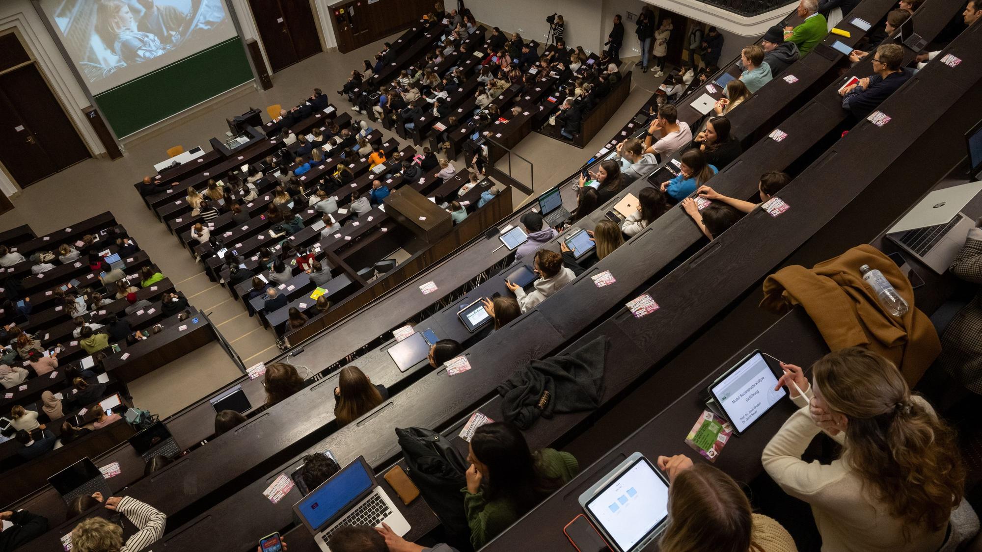 ARCHIV - 16.10.2023, Bayern, München: Studierende nehmen an der Einführungsveranstaltung im Audimax der Ludwig-Maximilians-Universität (LMU) teil. Das Studieren in Teilzeit - etwa neben festem Job oder Kinderbetreuung - bildet noch immer eine Nische. Zumindest, wenn man nach offiziellen Zahlen geht. Unter den Bundesländern gibt es große Unterschiede, wie eine Analyse zeigt. Foto: Peter Kneffel/dpa +++ dpa-Bildfunk +++
