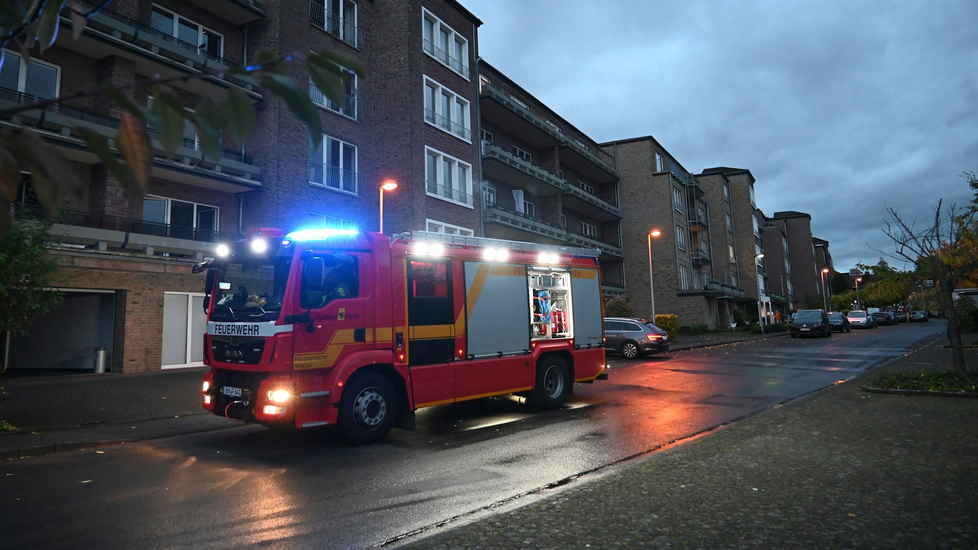 Ein Feuerwehrauto steht im Morgengrauen vor einem Bürogebäude.