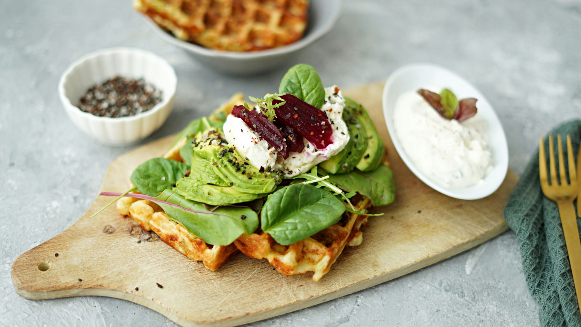 Der Kartoffelteig wird im Waffeleisen ausgebacken und mit einem herzhaftem Belag aus Salatblättern, Avocado, Mozzarella und Rote Bete getoppt.