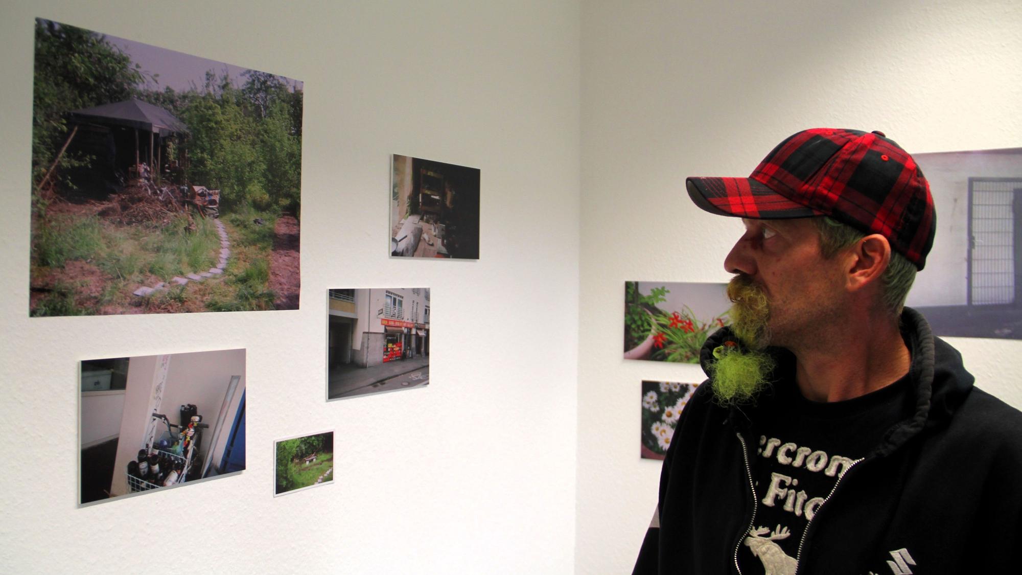 Fotograf Reiner betrachtet seine Ausstellungsmotive im Offenen Treff der Oase.