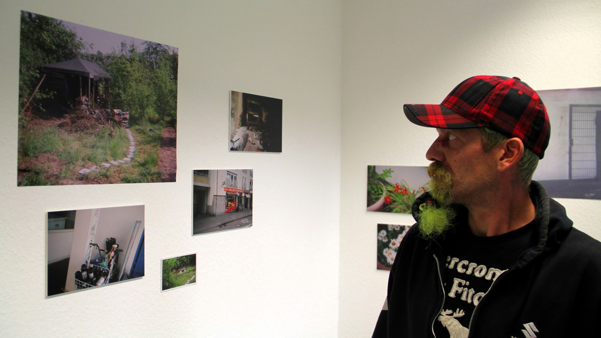 Fotograf Reiner betrachtet seine Ausstellungsmotive im Offenen Treff der Oase.