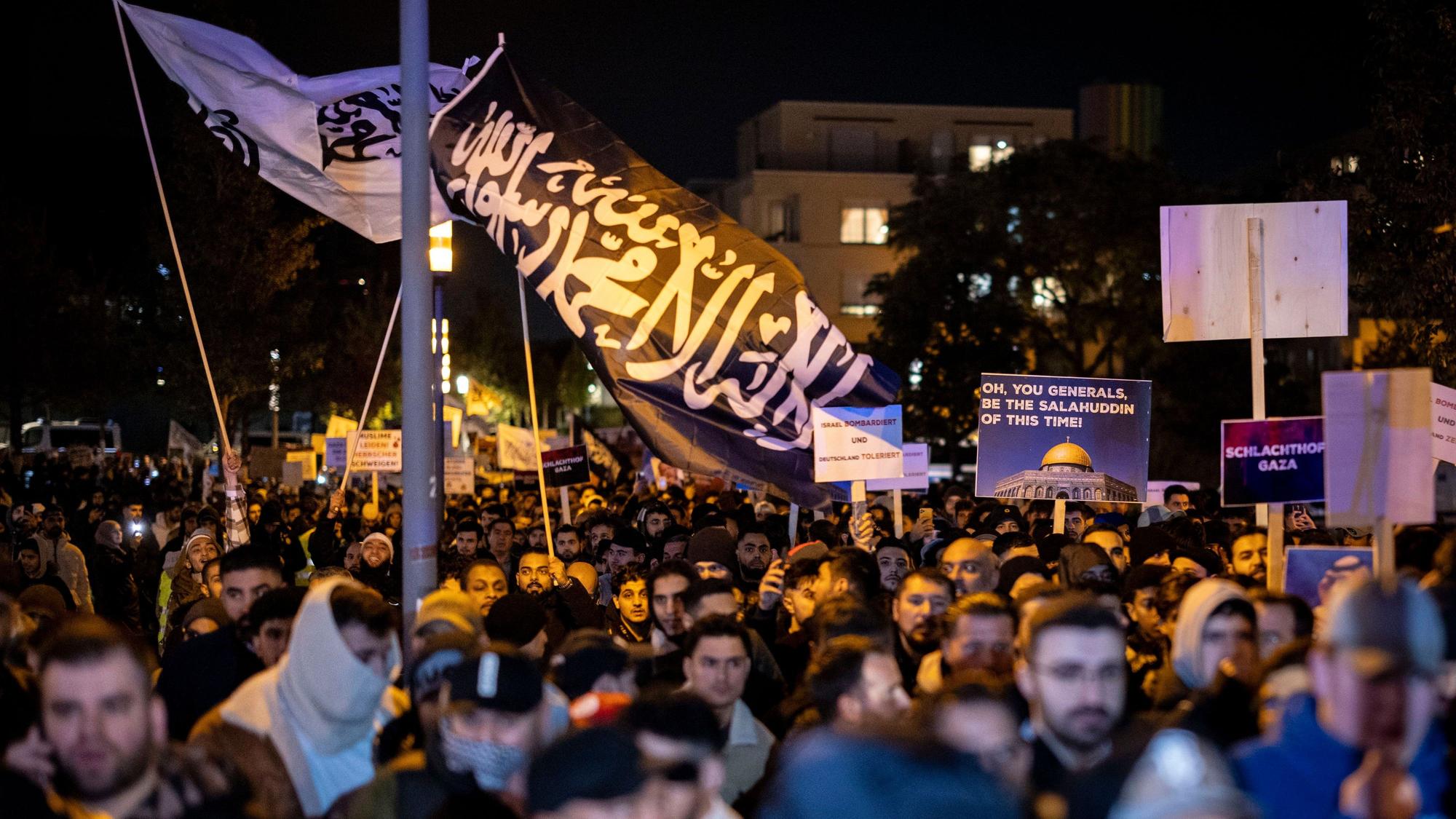 Essen: Eine Fahne mit arabischer Schrift weht bei der Kundgebung über einer Masse von Menschen.