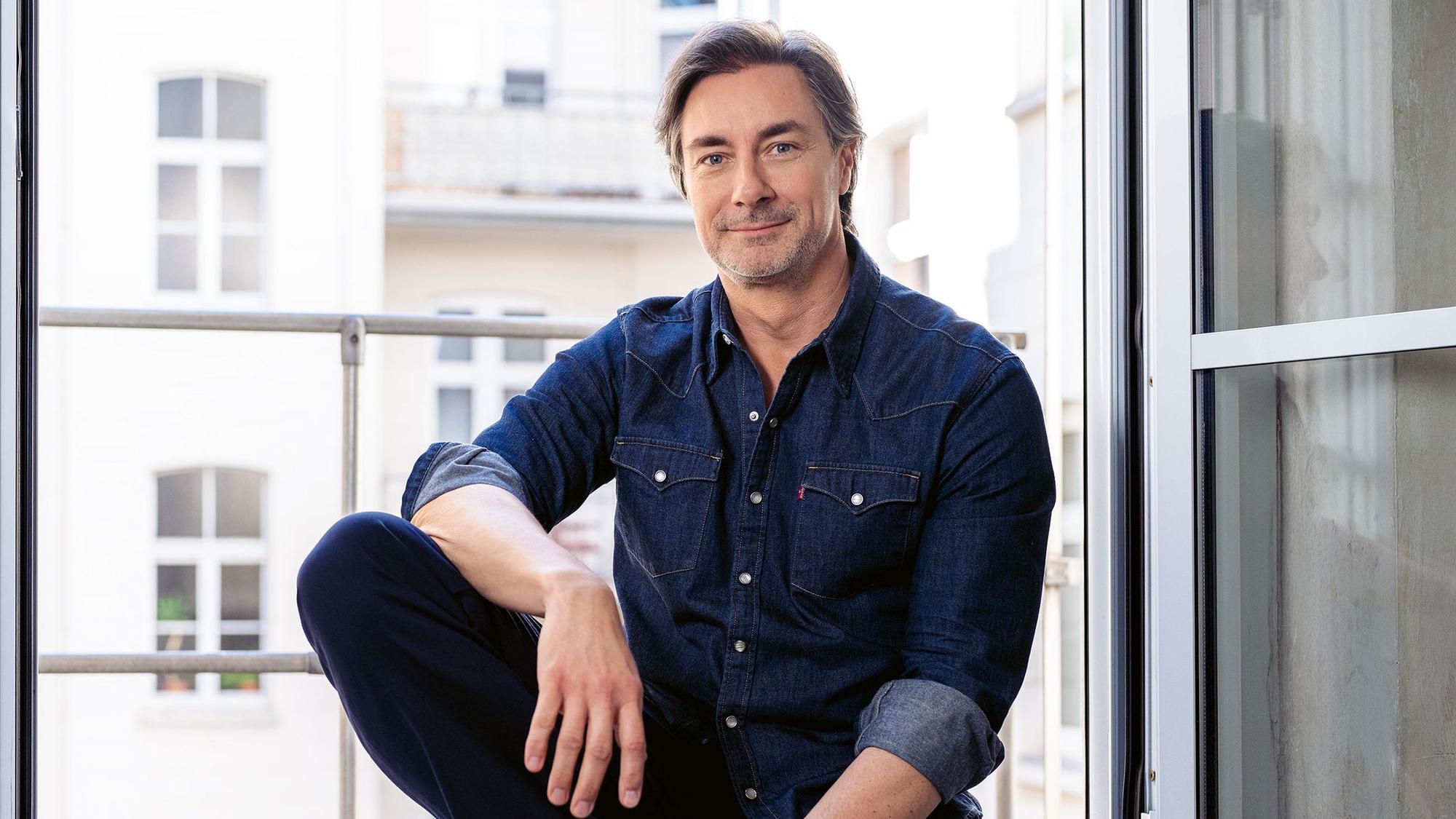 Moderator Marco Schreyl sitzt auf einer Fensterbank.