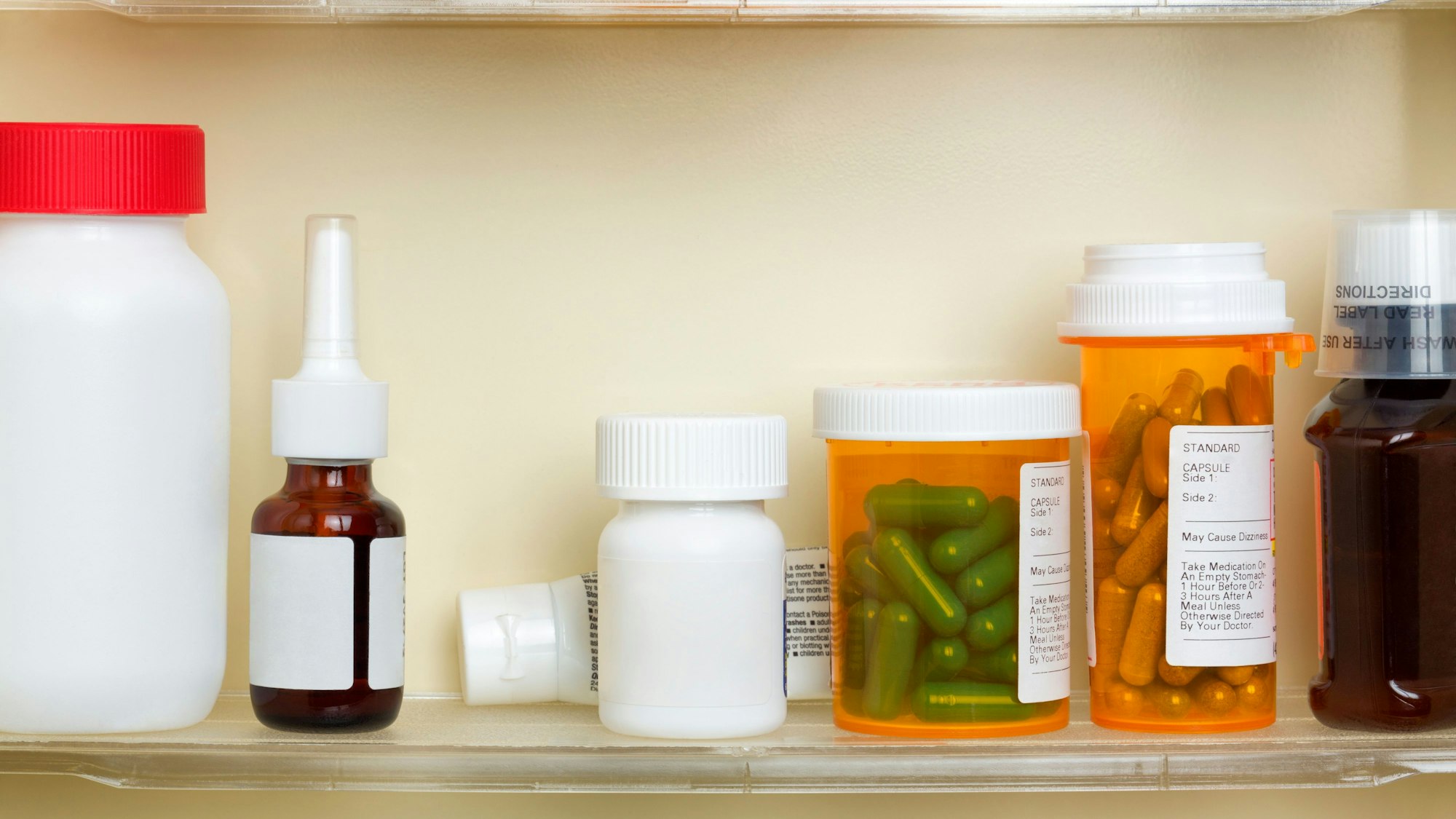 Fach im Medizinschrank mit Spray, Tuben und Tablettendosen.