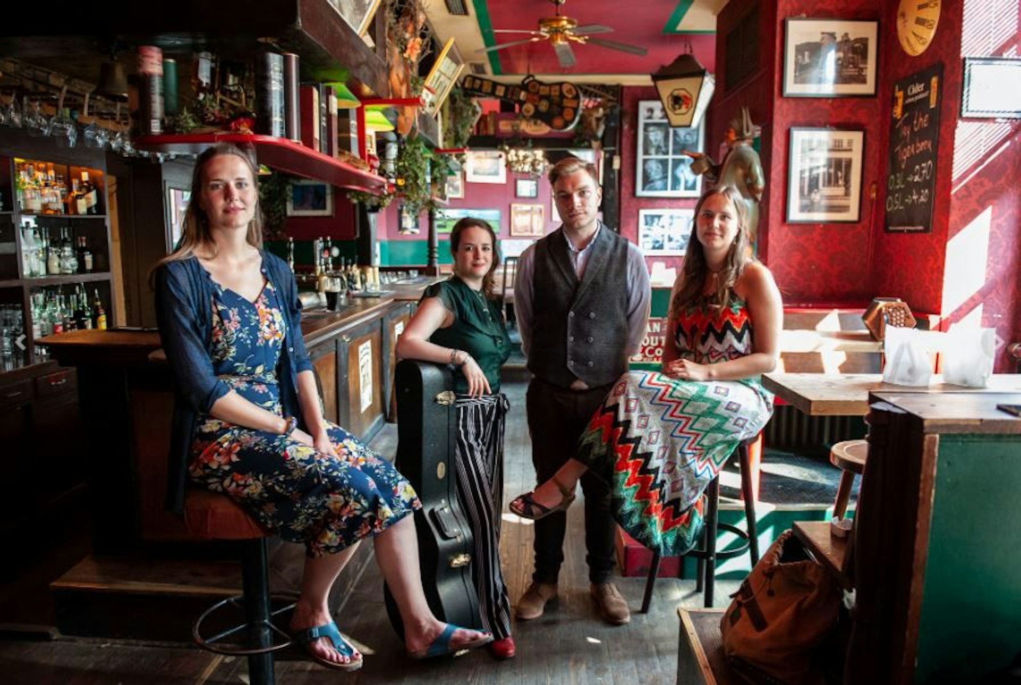 Die Mitglieder der Gruppe „Her Majesty calling“ sitzen in einer Kneipe.