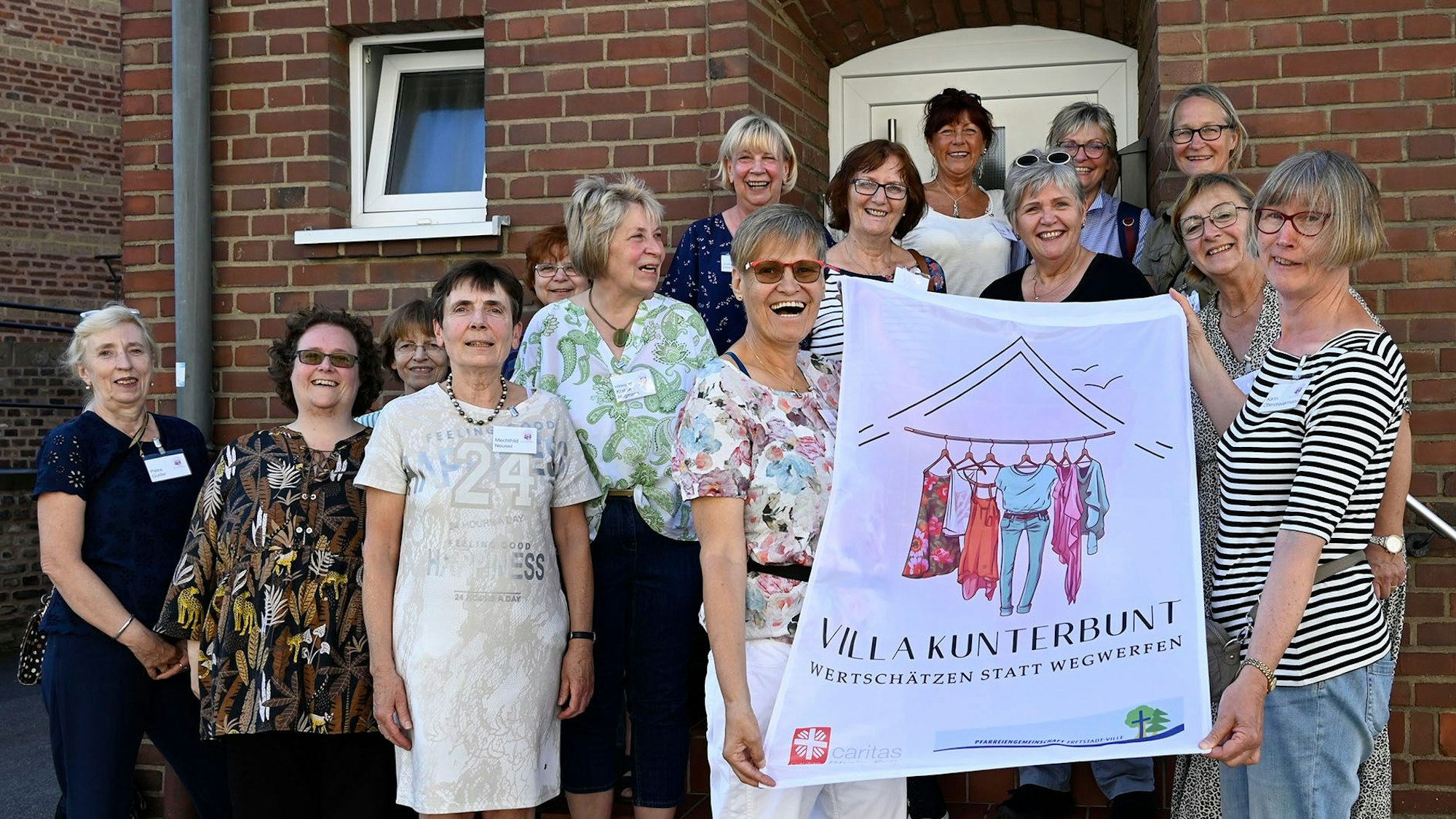 Eine Gruppe Frauen präsentiert das neue Logo der Kleiderkammer.