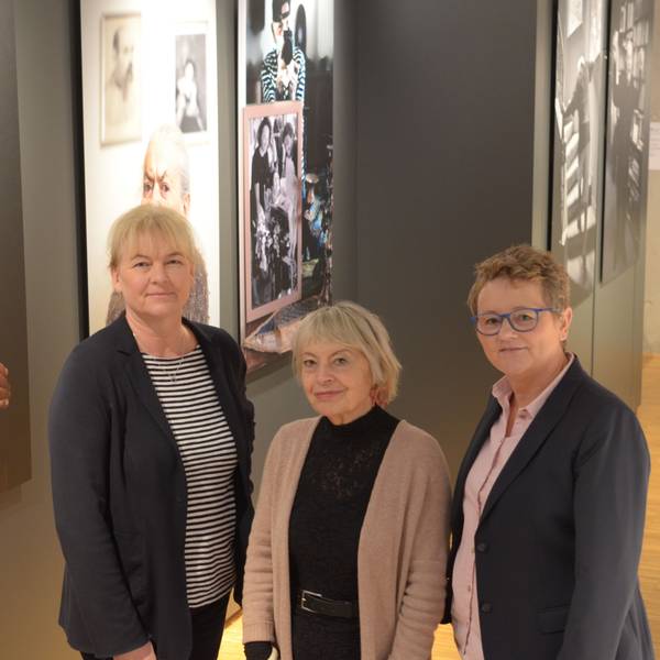 Dr. Heike Lützenkirchen (l.) und Petra Goerge (r.) stellen im Stadtmuseum Euskirchen mit Kuratorin Gisela Kayser die Sonderausstellung „Lonka Projekt“ vor. Sie stehen vor einer Reihe von Porträts von Holocaust-Überlebenden.