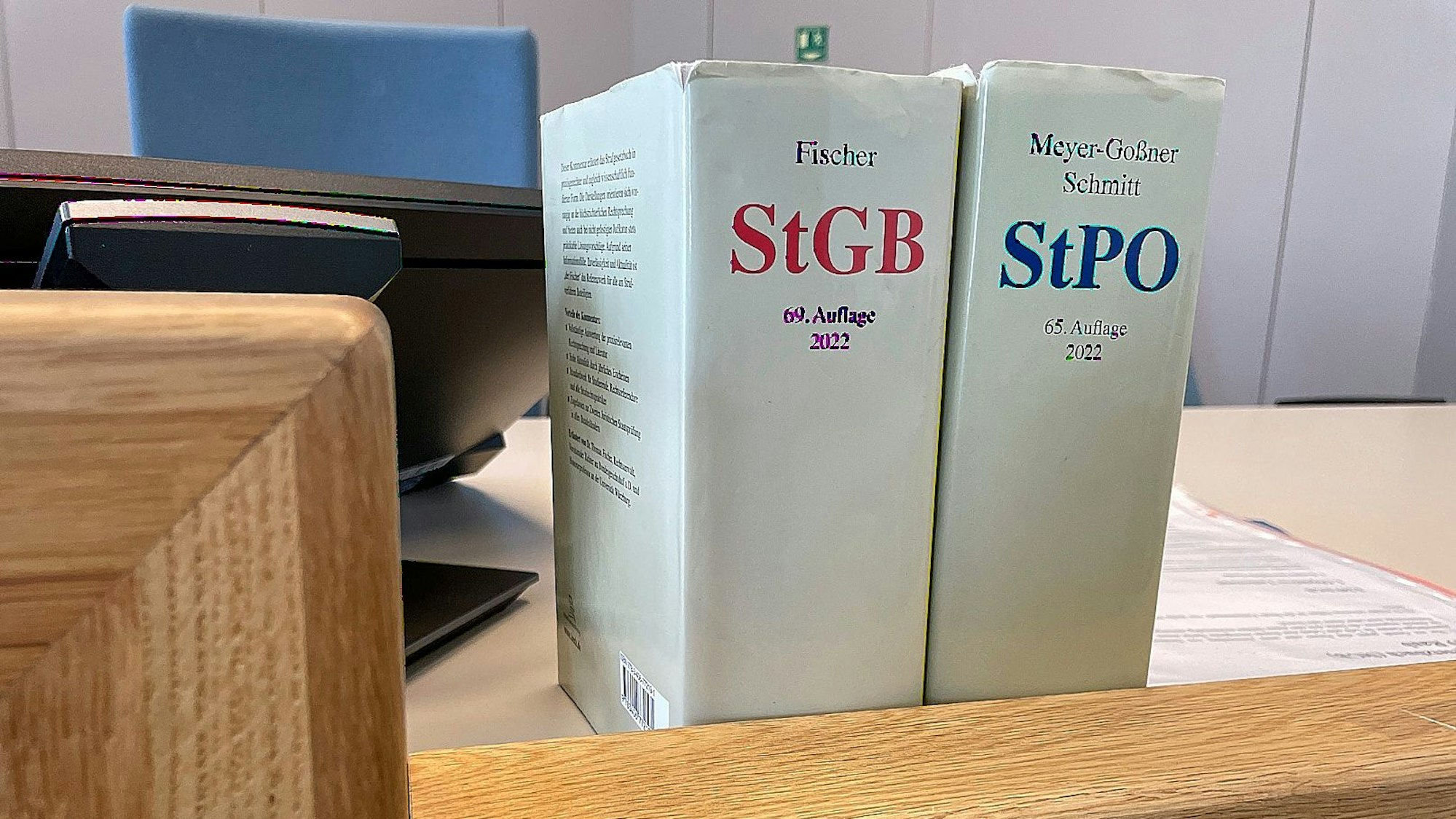 Das Bild zeigt Gesetzbücher auf dem Richtertisch eines Gerichts.