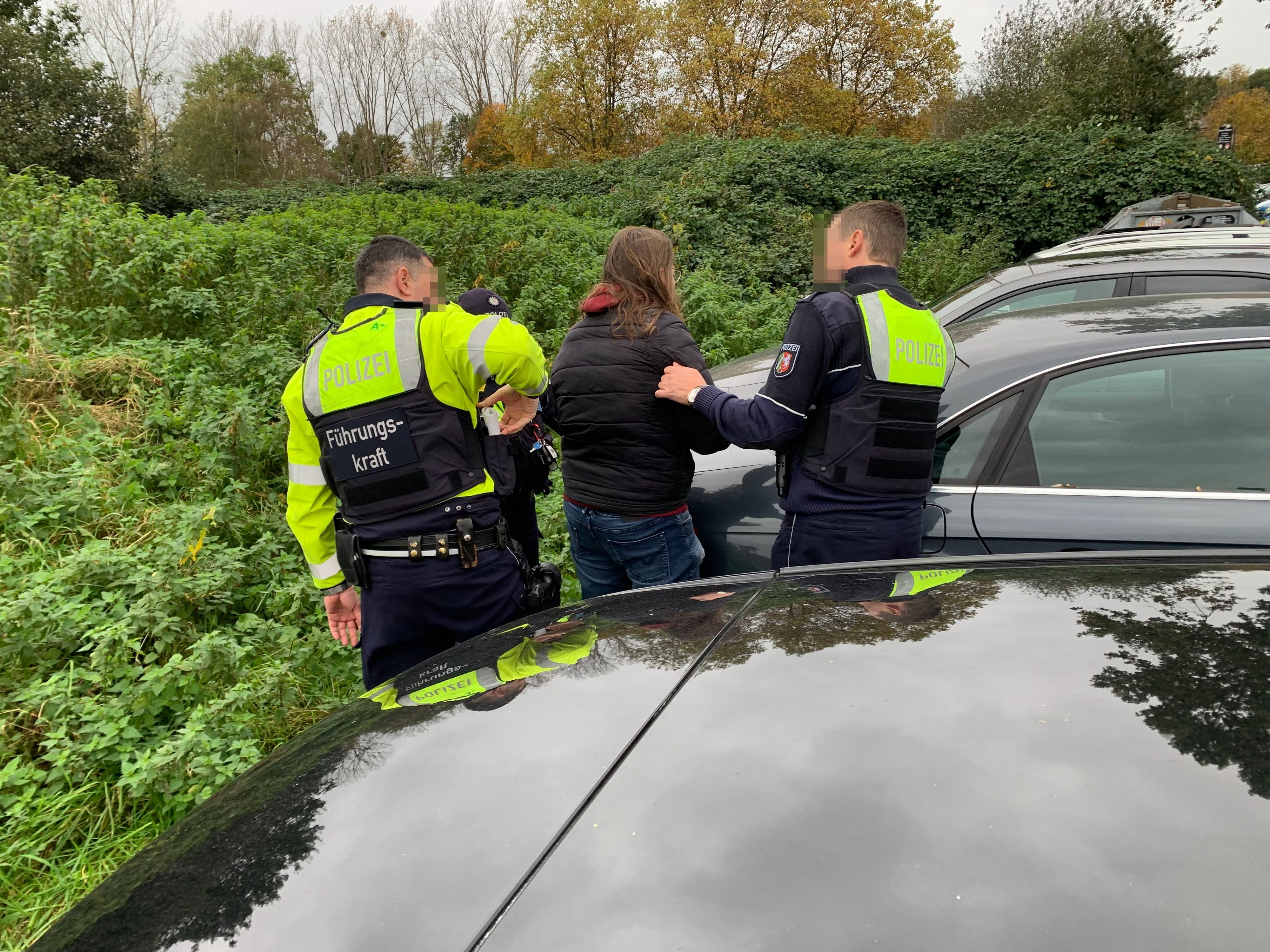 Die Polizei befragt einen Demonstranten aus der Gruppe der Linken nach seinen Personalien.