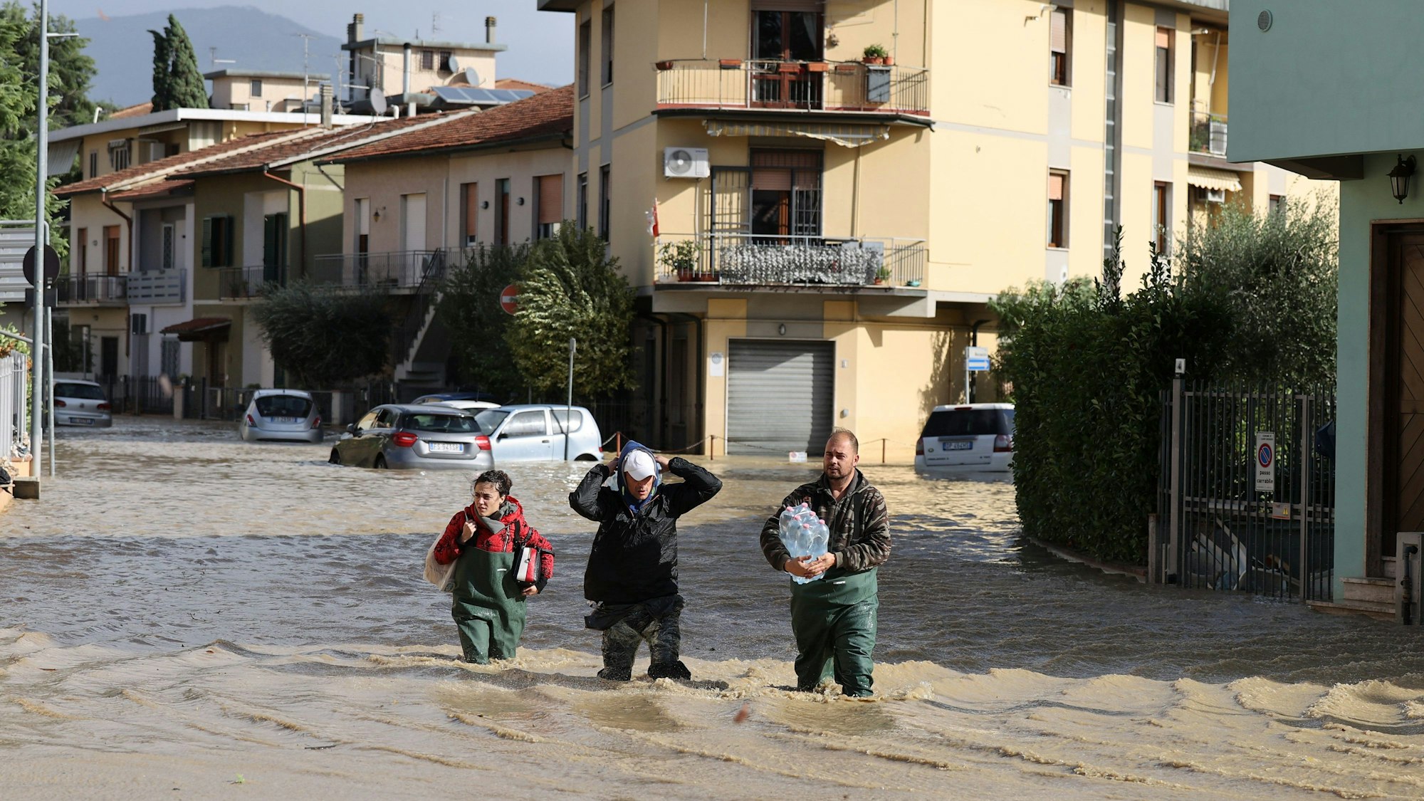 dpatopbilder - 03.11.2023, Italien, Toskana: Menschen gehen im Hochwasser über eine überschwemmte Straße. Schwere Unwetter mit heftigen Regenfällen haben die mittelitalienische Region Toskana in der Nacht zum Freitag heimgesucht. Foto: Str/Xinhua/dpa +++ dpa-Bildfunk +++