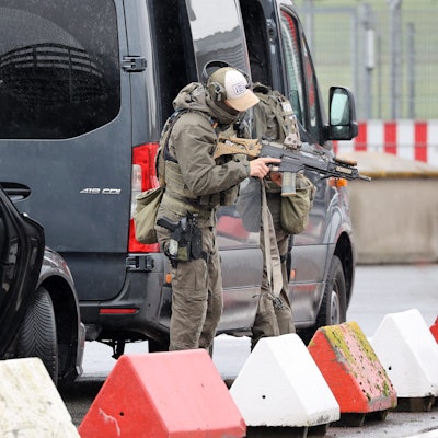 Schwer bewaffnete Spezialkräfte der Polizei bereiten sich am Flughafen auf einen Einsatz vor.