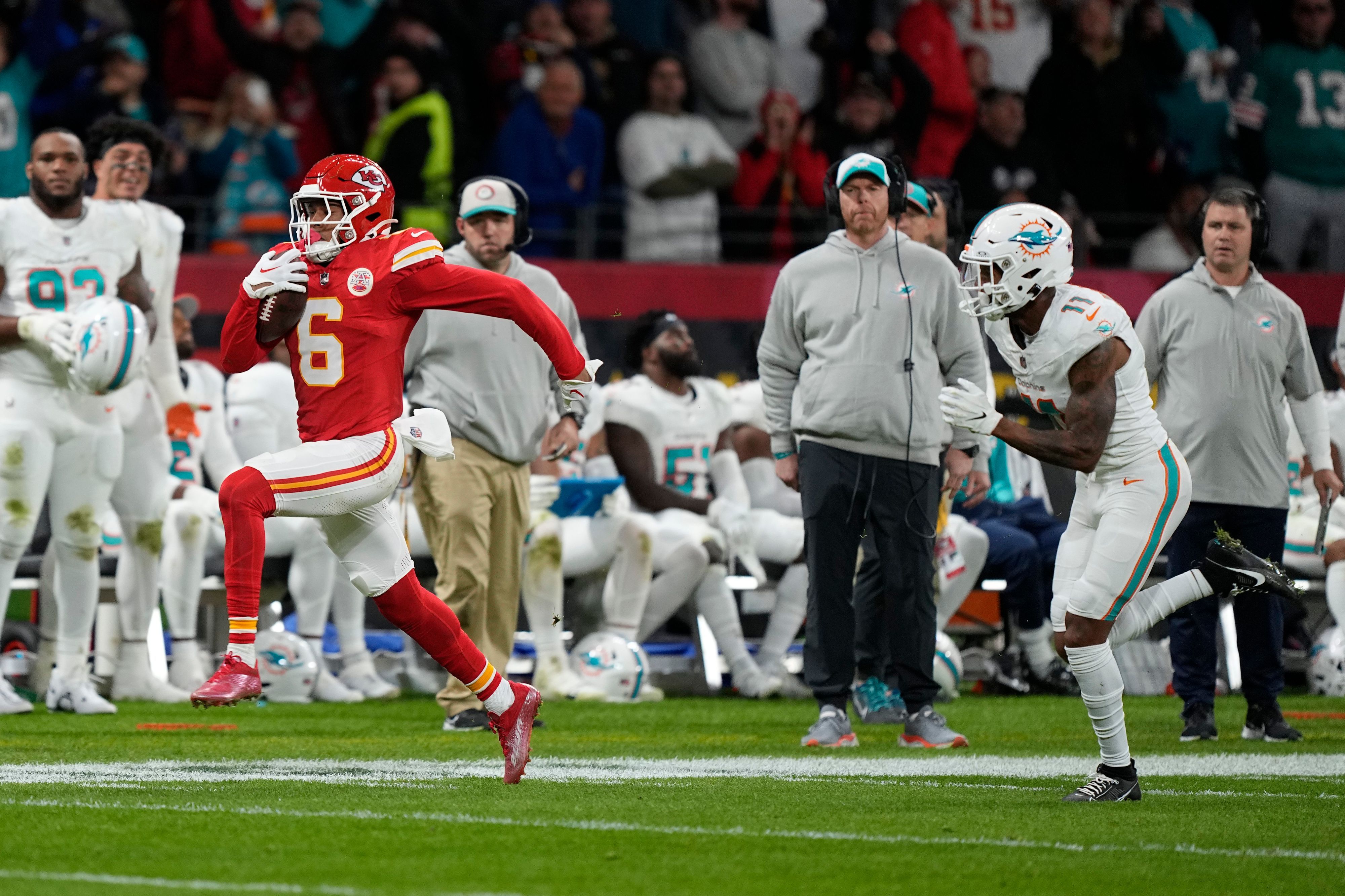 Kansas City Chiefs safety Bryan Cook (6) runs for a touchdown past Miami Dolphins wide receiver Cedrick Wilson Jr. after a fumble recovery by the Chiefs during the first half of an NFL football game Sunday, Nov. 5, 2023, in Frankfurt, Germany. (AP Photo/Martin Meissner)