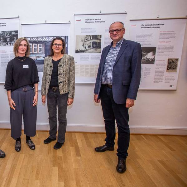 Das Foto zeigt vier Personen vor den Tafeln einer Ausstellung zum Thema Bücherverbrennung
