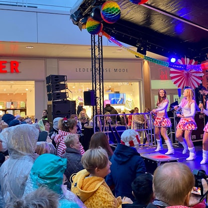 Frauen tanzen vor Publikum auf einer Bühne.