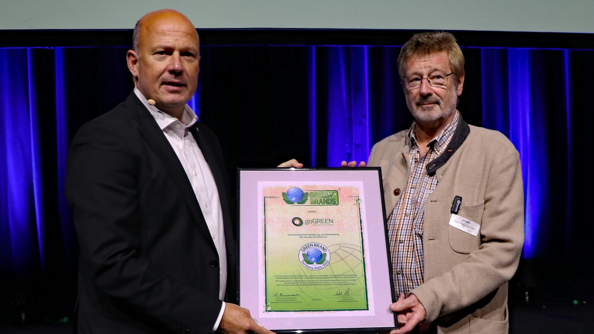 Zwei Männer halten eine Urkunde.