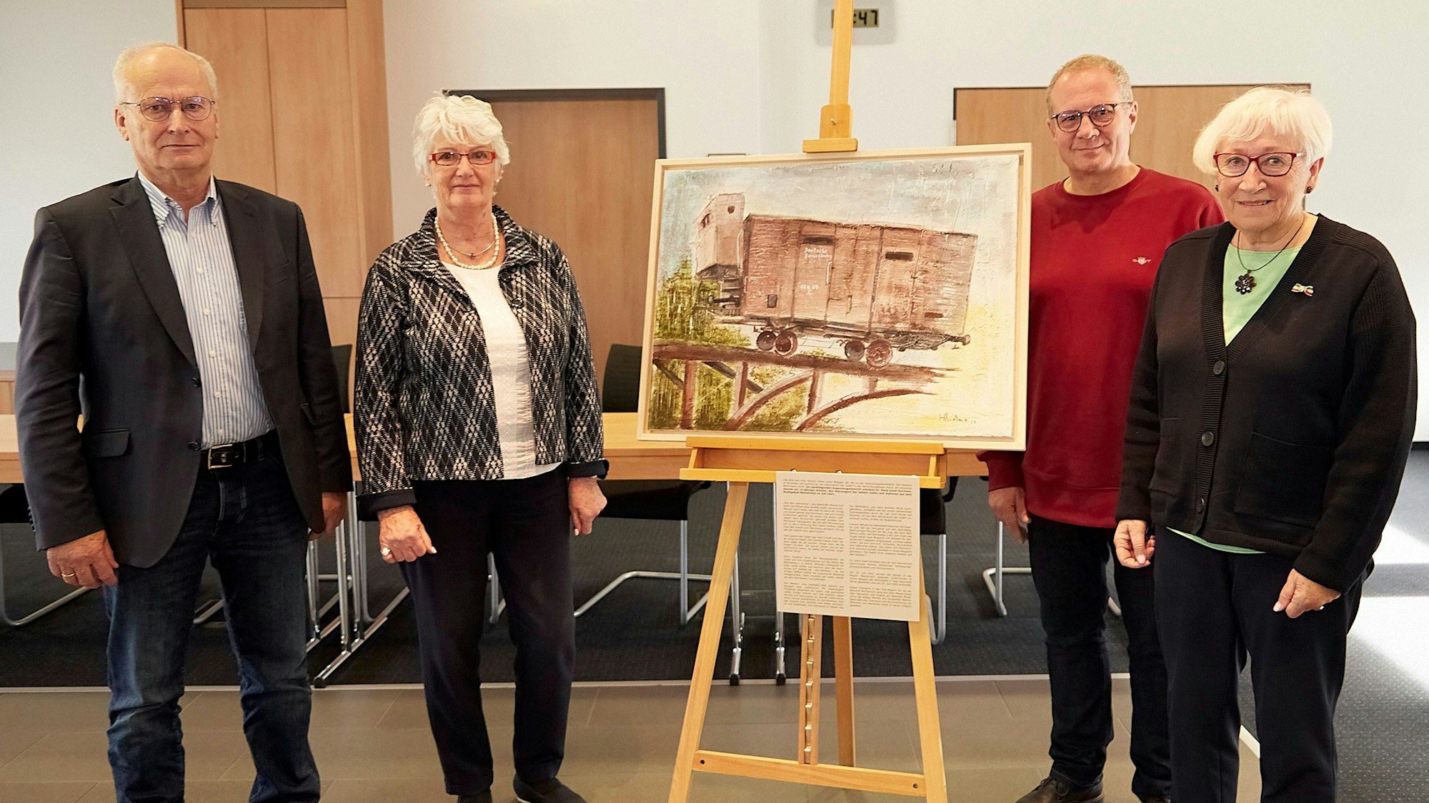 Die Gruppe mit dem Gemälde auf einer Staffelei.