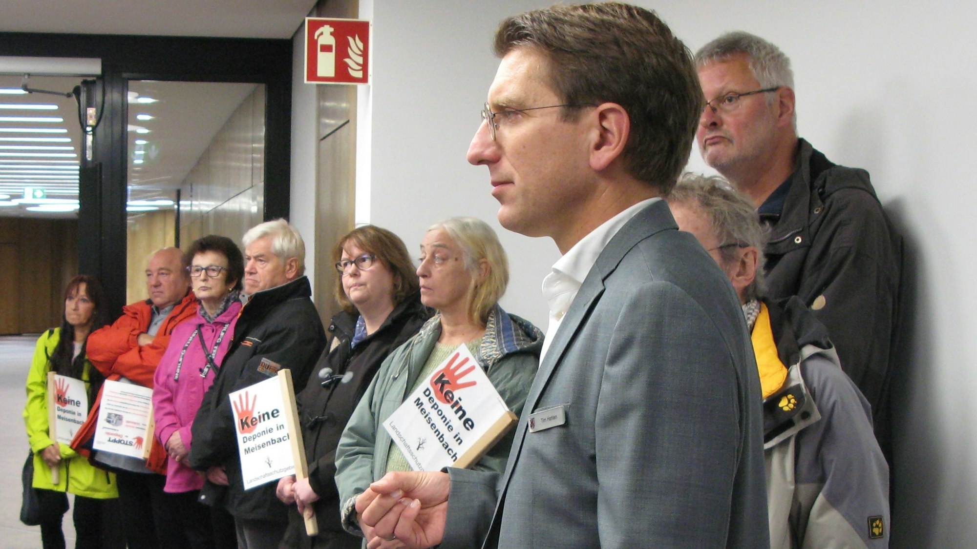 Im Kreishaus stehen der Umweltdezernent Tim Hahlen und eine Gruppe von Bürgern aus Meisenbach auf einem Flur.