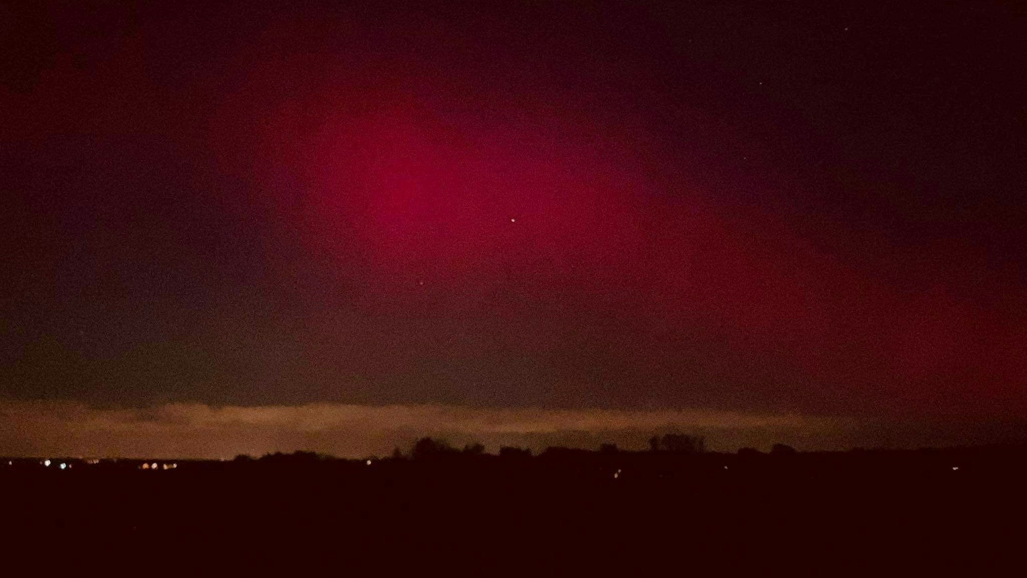 Das Bild zeigt rote Nordlichter am Himmel