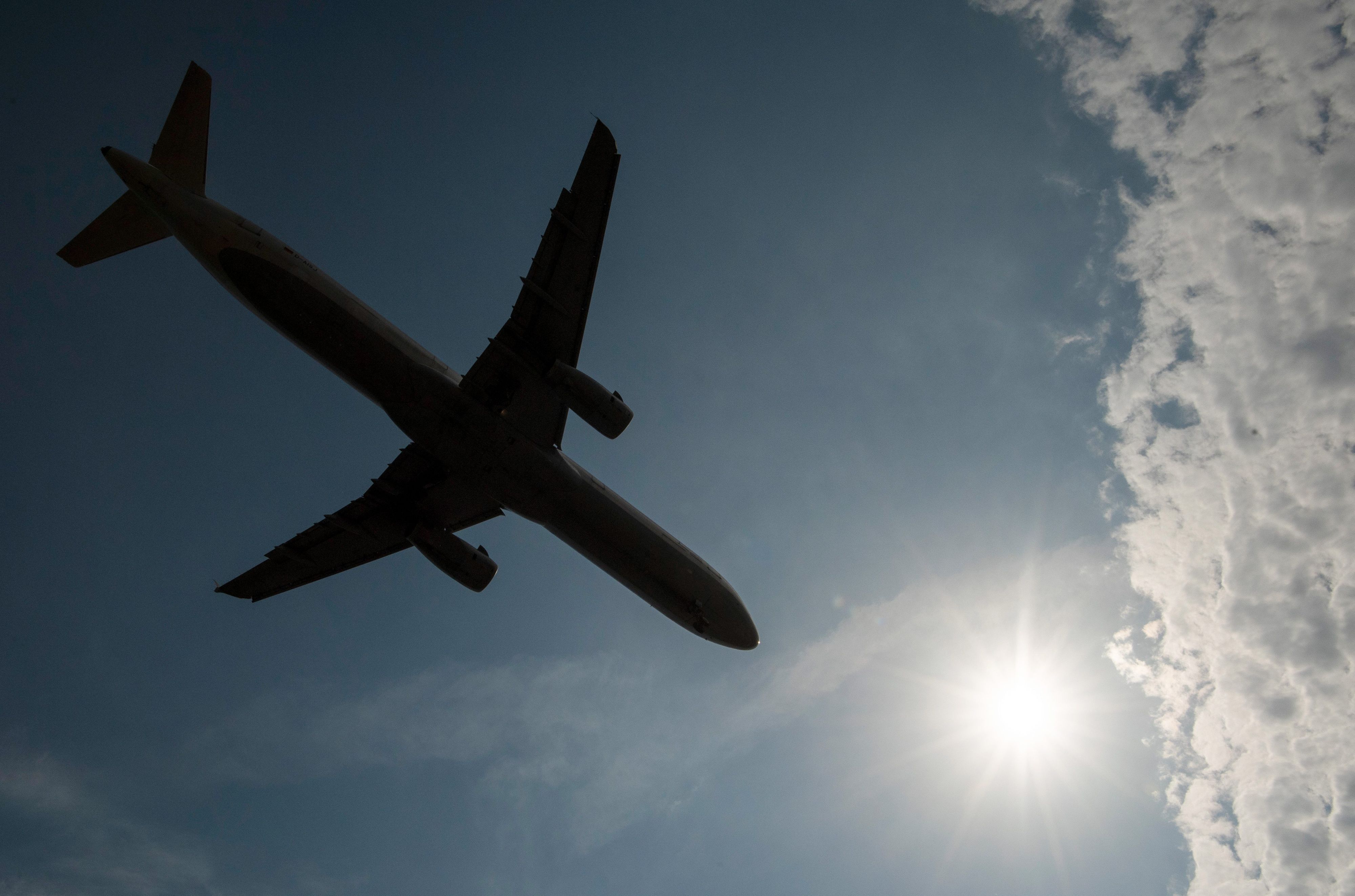 Vorbei an einem Wolkenfeld landet eine Passagiermaschine auf dem Flughafen.