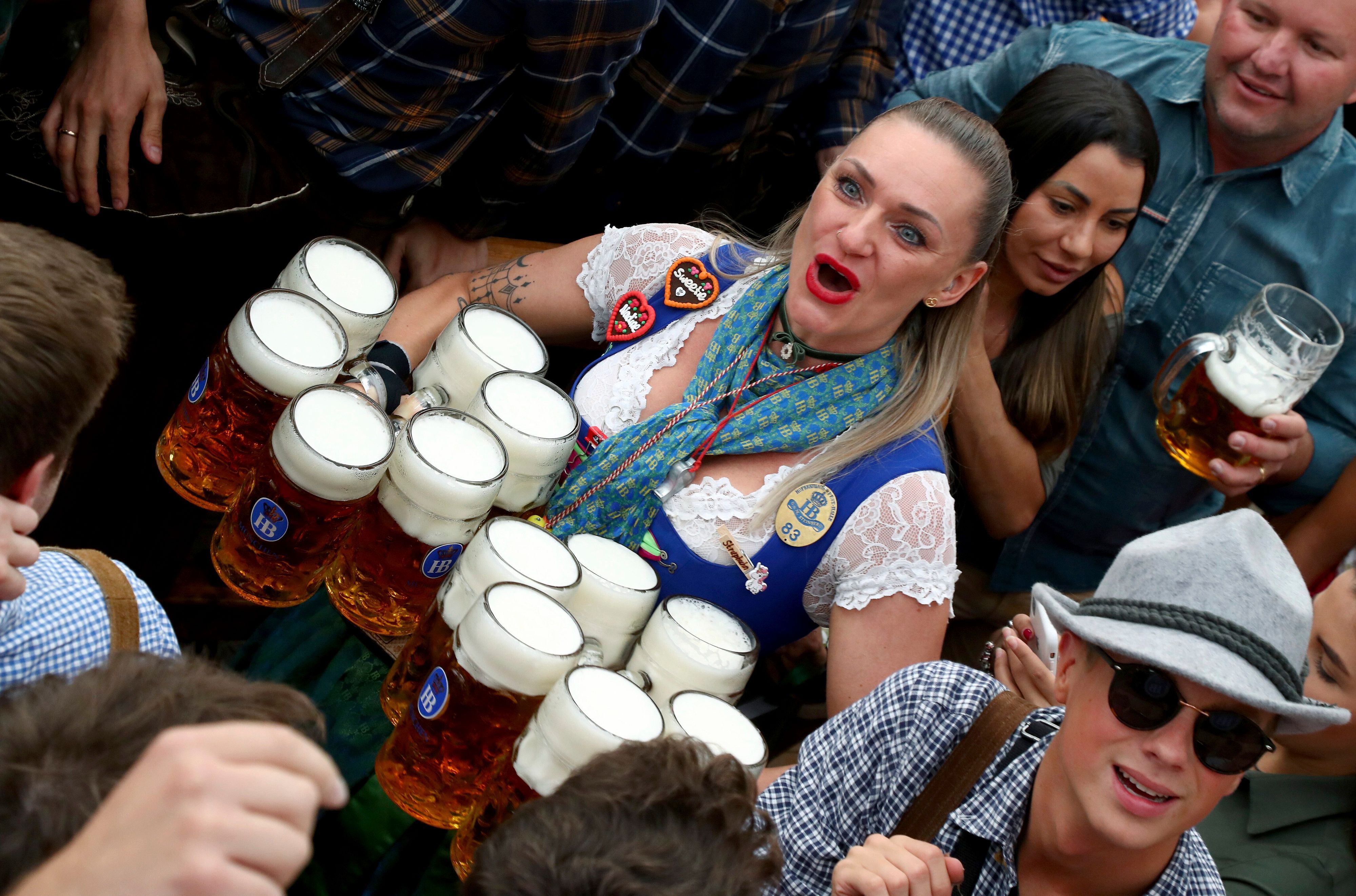 Eine Kellnerin verteilt zwölf Maß Bier auf dem Oktoberfest.