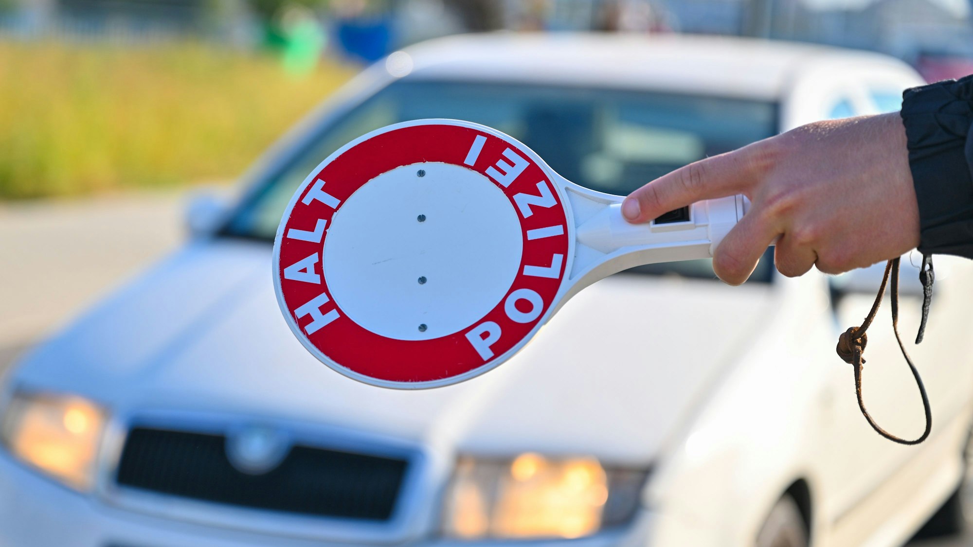 Ein Beamter der Bundespolizei stoppt den Fahrer eines Autos bei der Einreise bei einer Kontrolle gegen die Schleuserkriminalität.
