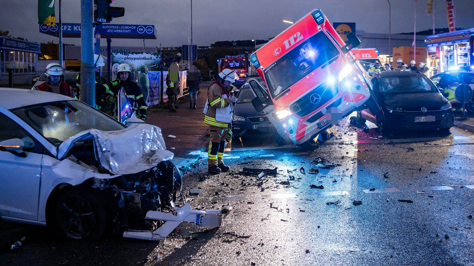 Das Bild zeigt die Szenerie des Unfalls. Im Vordergrund ein demoliertes Auto zu sehen, im Hintergrund der RTW, der auf zwei Auto gelandet ist.