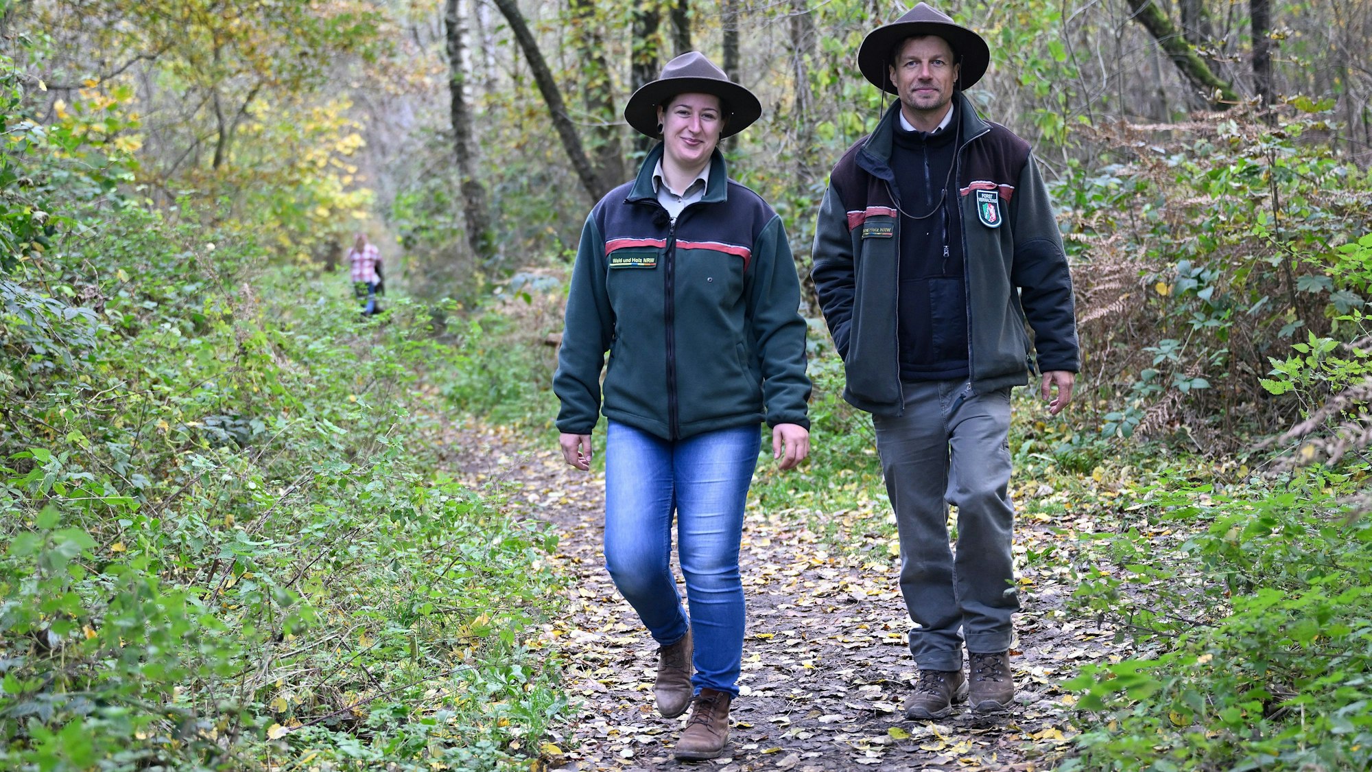 Neue Rangerin und neuer Ranger gehen durch das Naturschutzgebiet der Grube Cox in Bergisch Gladbach.