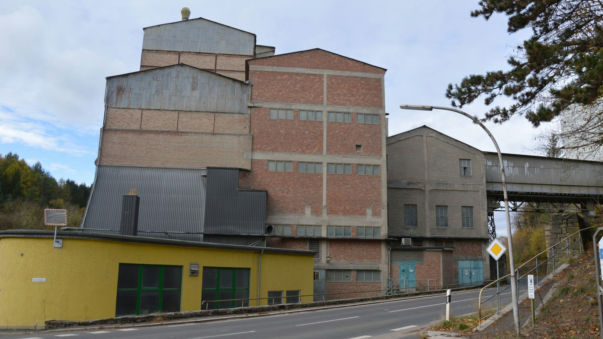 Hohe Fabrikgebäude stehen unmittelbar an der L204.