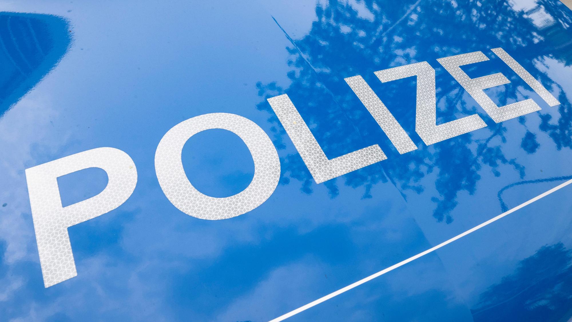 Der Schriftzug „Polizei“ ist auf einem Streifenwagen zu lesen.